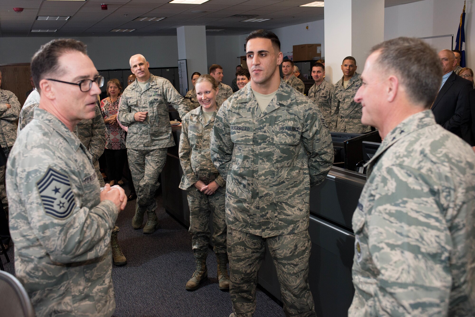 Chief Master Sgt. Roger Towberman, 25th Air Force Command Chief, left, introduces Staff Sgt. Salvatore Guerriero, center, to Gen. David Goldfein, the Air Force vice chief of staff, standing center. On Thursday, Goldfein presented a coin to Guerriero, a client systems technician, to recognize his actions during an attack on his deployed location in Afghanistan, which earned him the Air Force Combat Action medal.  
