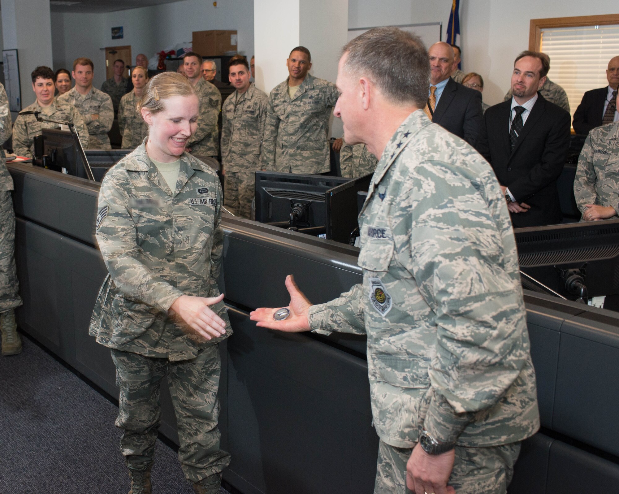 Air Force Vice Chief of Staff Gen. David Goldfein, right, presents his coin to Staff Sgt. Elizabeth, center, from the 363rd Intelligence, Surveillance and Reconnaissance Wing. Elizabeth’s wing commander nominated her for the recognition in part for maturing a new electronic warfare function in less than half of the two years scheduled for the process. The Air Force does not fully identify ISR personnel for security reasons. 
