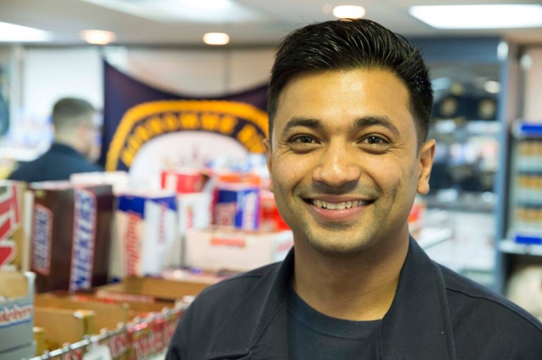Navy Seaman Aashis Luitel, a ship’s serviceman, is pictured in the ship’s store aboard the amphibious assault ship USS Bonhomme Richard in Okinawa, Japan, Feb. 28, 2016. Luitel manages the ship’s service storerooms, a position usually held by sailors senior to him in rank. Navy photo by Seaman William Sykes