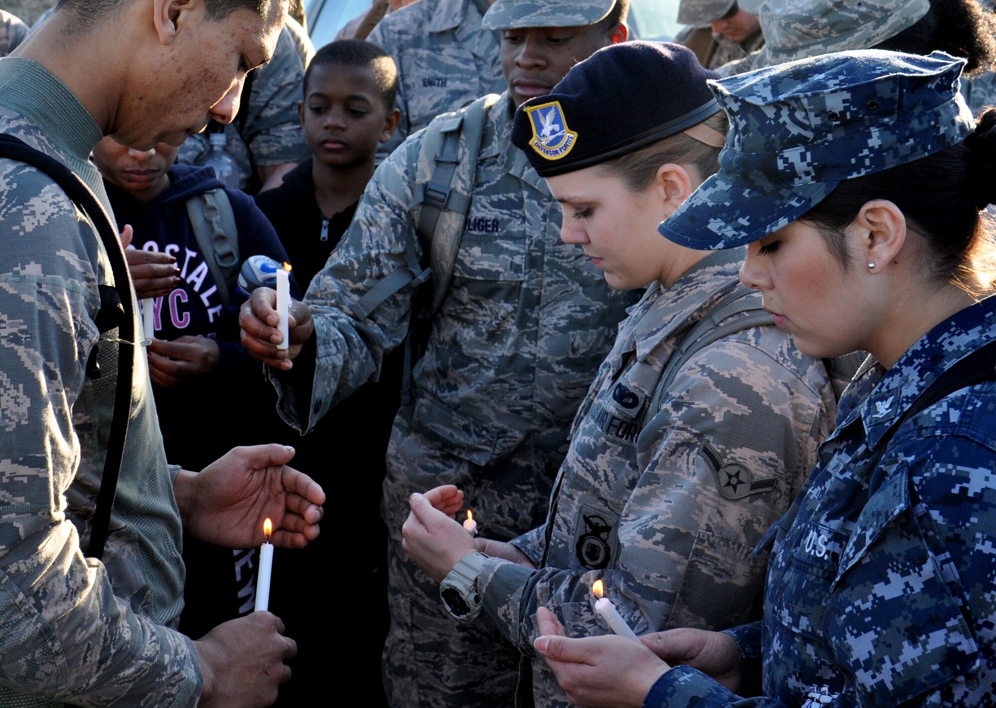 Team Offutt members bow their heads for a moment of silence during a candle light vigil for the late U.S. Air Force Staff Sgt. Michael Bunten, 55th Security Forces Squadron, March 5, 2016, at Haworth Park, Bellevue, Neb. Bunten passed away in a motor vehicle accident while home on leave in Eugene, Oregon.  