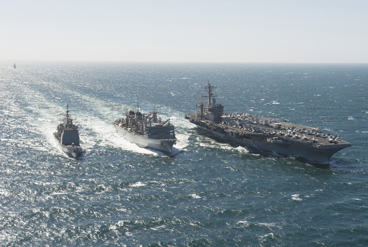 The aircraft carrier USS Carl Vinson and the guided-missile cruiser USS Bunker Hill conduct a fuel replenishment in the Arabian Sea with the Military Sealift Command fast combat support ship USNS Bridge, center, as the Royal Navy destroyer HMS Daring, background, approaches, March 6, 2012. Navy photo by Mass Communication Specialist 2nd Class James R. Evans
