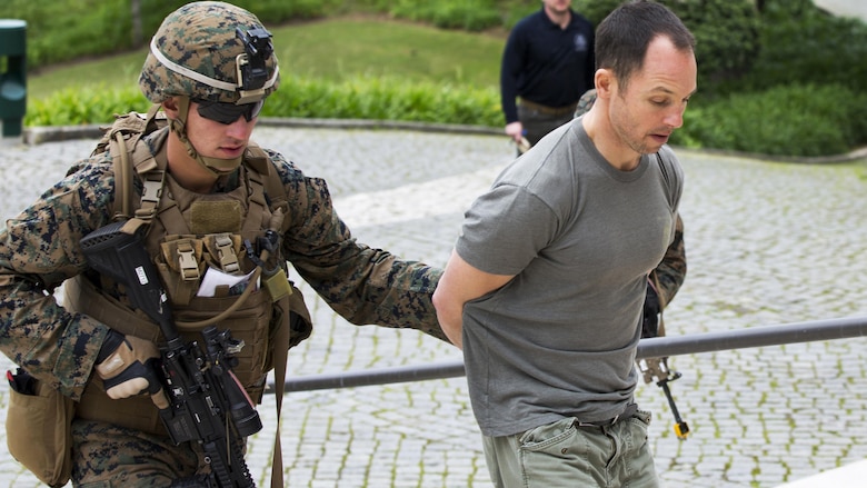 U.S. Marine Corps Lance Cpl. Noah S. Scalish, (left), automatic rifleman, 2nd platoon Bravo Company, 1st Battalion, 8th Marine Regiment, Special-Purpose Marine Air-Ground Task Force-Crisis Response-Africa escorts a simulated suspect during an active shooter exercise at U.S. Embassy, Lisbon, Portugal, Feb. 9, 2016. SPMAGTF-CR-AF conducts a scaled embassy reinforcement exercise at American Embassy Lisbon in coordination with the Regional Security Office and host nation security forces in order to enhance mission essential  task proficiency and build relationships. 