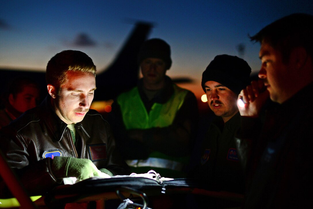 Pilots and crew review flight plans on the flightline at Istres-Le Tubé Air Base, France, Feb. 26, 2016. Air Force photo by Senior Airman Erin Trower