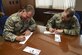 Col. Mark Slocum (left), 4th Fighter Wing commander, and Chief Master Sgt. Shane Wagner, 4th FW command chief, fill out donations slips for the 2016 Air Force Assistance Fund, March 3, 2016, at Seymour Johnson Air Force Base, North Carolina. The AFAF campaign began Feb. 29 and ends April 8 with a goal of raising $100,000. (U.S. Air Force photo/Airman Shawna L. Keyes)  