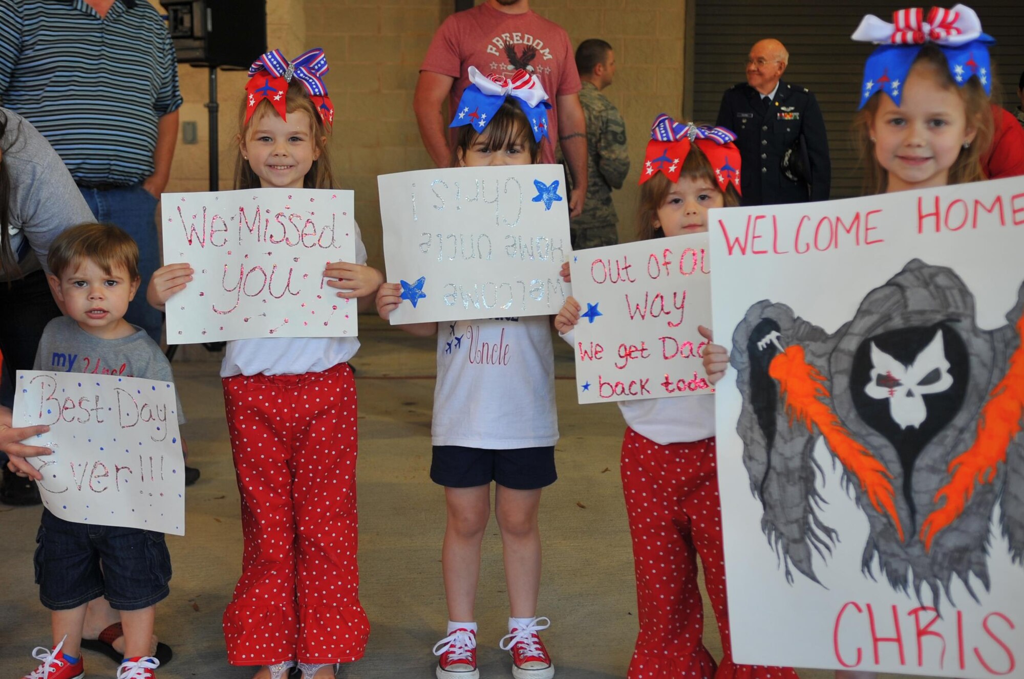 The family of Senior Airman Christopher Pirtle, crew chief with the 1st Special Operations Aircraft Maintenance Squadron, display signs they made for his return during Operation Homecoming at the deployment control center, Hurlburt Field, Fla., March 6, 2016. Pirtle, along with other Air Commandos, returned home from an overseas deployment. (U.S. Air Force photo by Airman 1st Class Joseph Pick)
