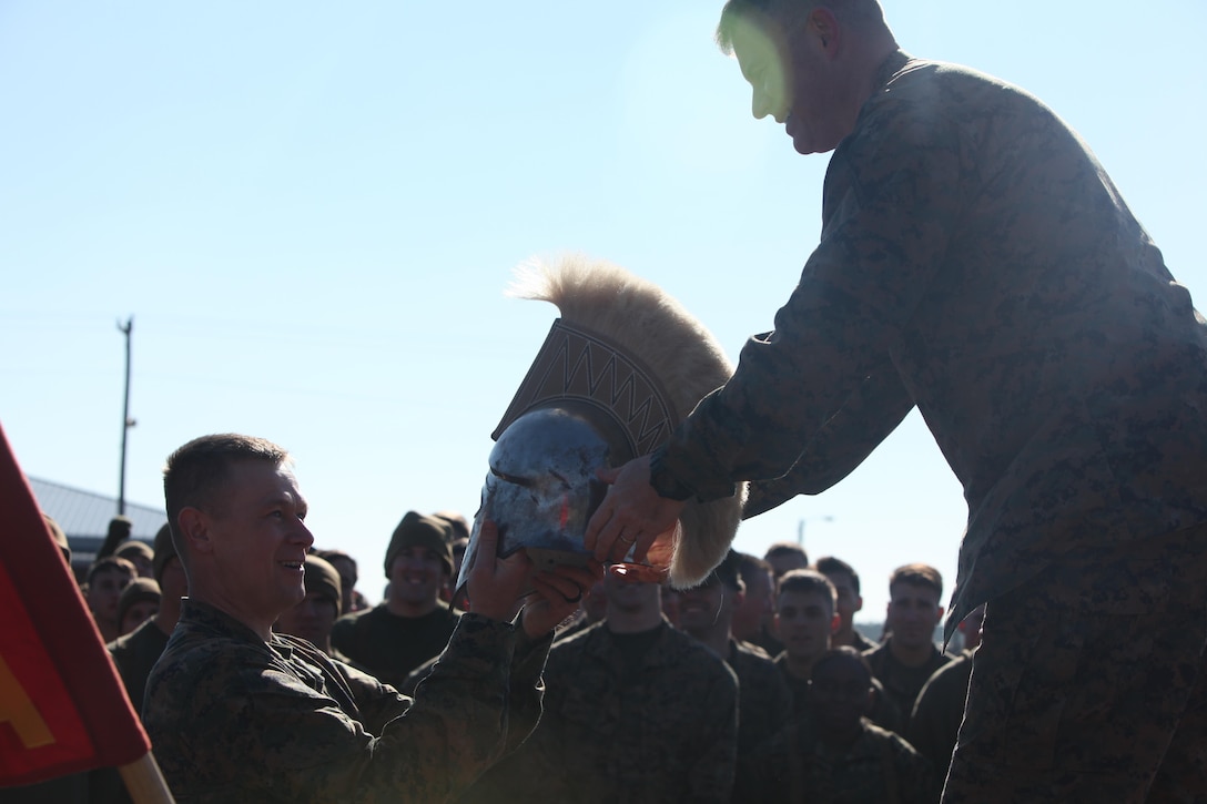 Lieutenant Col. Bret Hyla hands Capt. Ronnie Creech the Spartan helmet after the Marine Wing Communication Squadron semi-annual Spartan Cup field meet at Marine Corps Air Station Cherry Point, N.C., Jan. 29. The Marines competed in various activities, including tug-of-war and the running of the ranks, in which the three companies battled head-to-head to win the squadron’s Spartan Cup. The field meet is held to further strengthen esprit de corps and unit cohesion within the squadron, and to foster a sense of unit pride while improving Marines’ overall readiness. Hyla is the commanding officer of MWCS-28 and Creech is the company commander for Company A, MWCS-28. (U.S. Marine Corps photo by Cpl. Unique Roberts/ Released)
