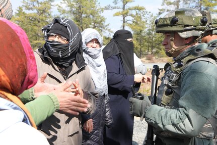 A U.S. Army Soldier assigned to the 957th Quartermaster Company (QM Company) speaks with notional local nationals during a simulated peaceful protest on Joint Base McGuire-Dix-Lakehurst, N.J., March 6, 2016. Soldiers of the 957th QM Company are participating in Combat Support Training Exercise 78-16-01 to improve unit readiness.