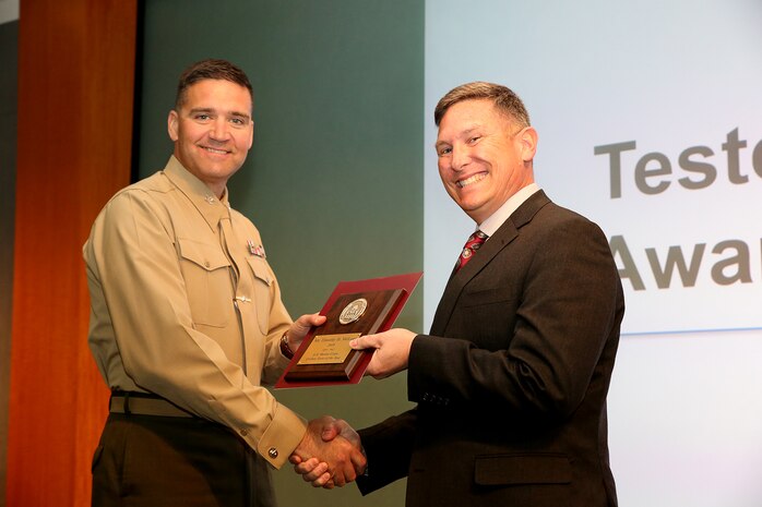 Timothy D. McLean (right), a senior technical advisor within the Marine Corps Tactical Systems Support Activity Test and Certification Group, receives the National Defense Industrial Association 2016 Tester of the Year Award from Col. Benjamin Stinson, commanding officer of MCTSSA. The award is presented to outstanding individuals in the field of Test and Evaluation. (U.S. Marine Corps photo by Emily Greene)