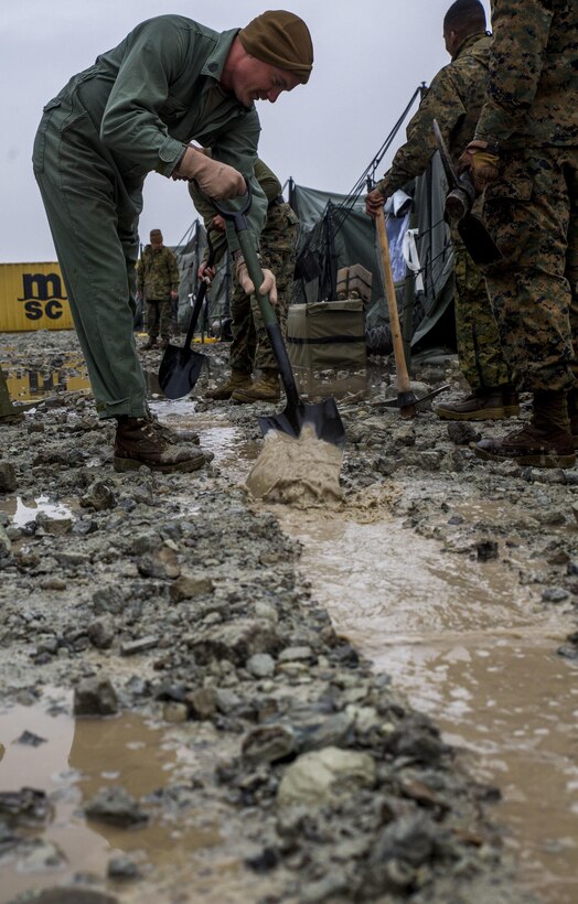 Gunnery Sgt. Shawn McLouth, from Grand Rapids, Michigan, pushes water toward a main trench, March 4, 2016 in Gwangyang, Republic of Korea. The water made the camp temporarily inoperable but the Marines were able to adapt to the situation and remove the water. Gwanyang Port is being used for reception, staging, and onward integration of Marines and equipment as part of Ssang Yong 16 and Freedom Banner 16. Ssang Yong 16 is a biennial combined amphibious exercise conducted by forward-deployed U.S. forces with the Republic of Korea Navy and Marine Corps, Australian Army and Royal New Zealand Army Forces in order to strengthen our interoperability and working relationships across a wide range of military operations - from disaster relief to complex expeditionary operations. McLouth is the maintenance chief for 1st Tanks Battalion. (U.S. Marine Corps photo by Lance Cpl. Kelsey M. Dornfeld/ Released)