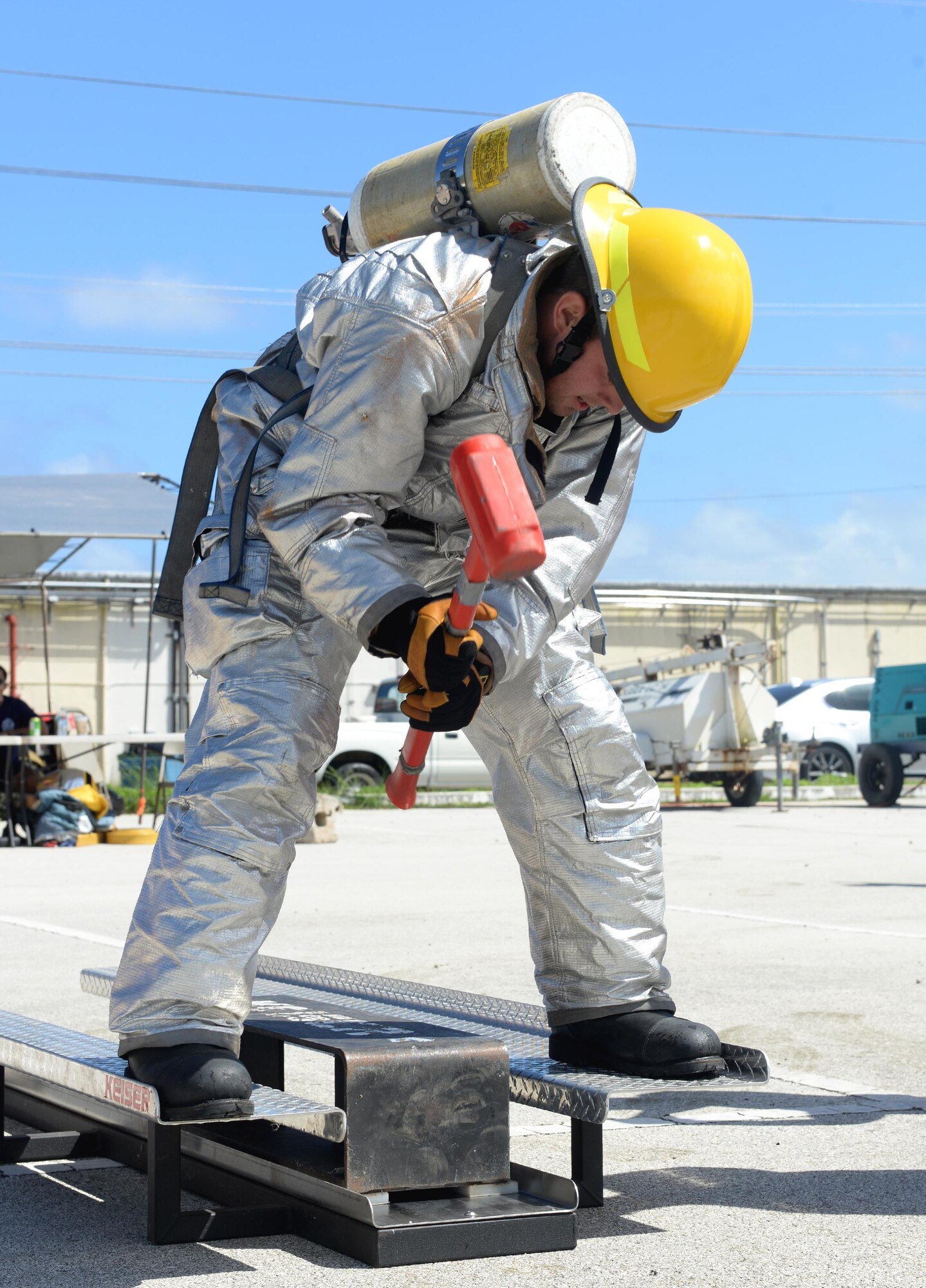 Airman 1st Class Zach Hamlette, 36th Civil Engineer Squadron fire protection crew chief, hits a weight during the annual Guam Fire Muster competition March 5, 2016, in Hagåtña, Guam. Hamlette used a sledgehammer to hit a weight across a Keiser sled, which is used to train firefighters on how to use axes for forced entry and ventilation on roofs and floors. (U.S. Air Force photo/Staff Sgt. Benjamin Gonsier)