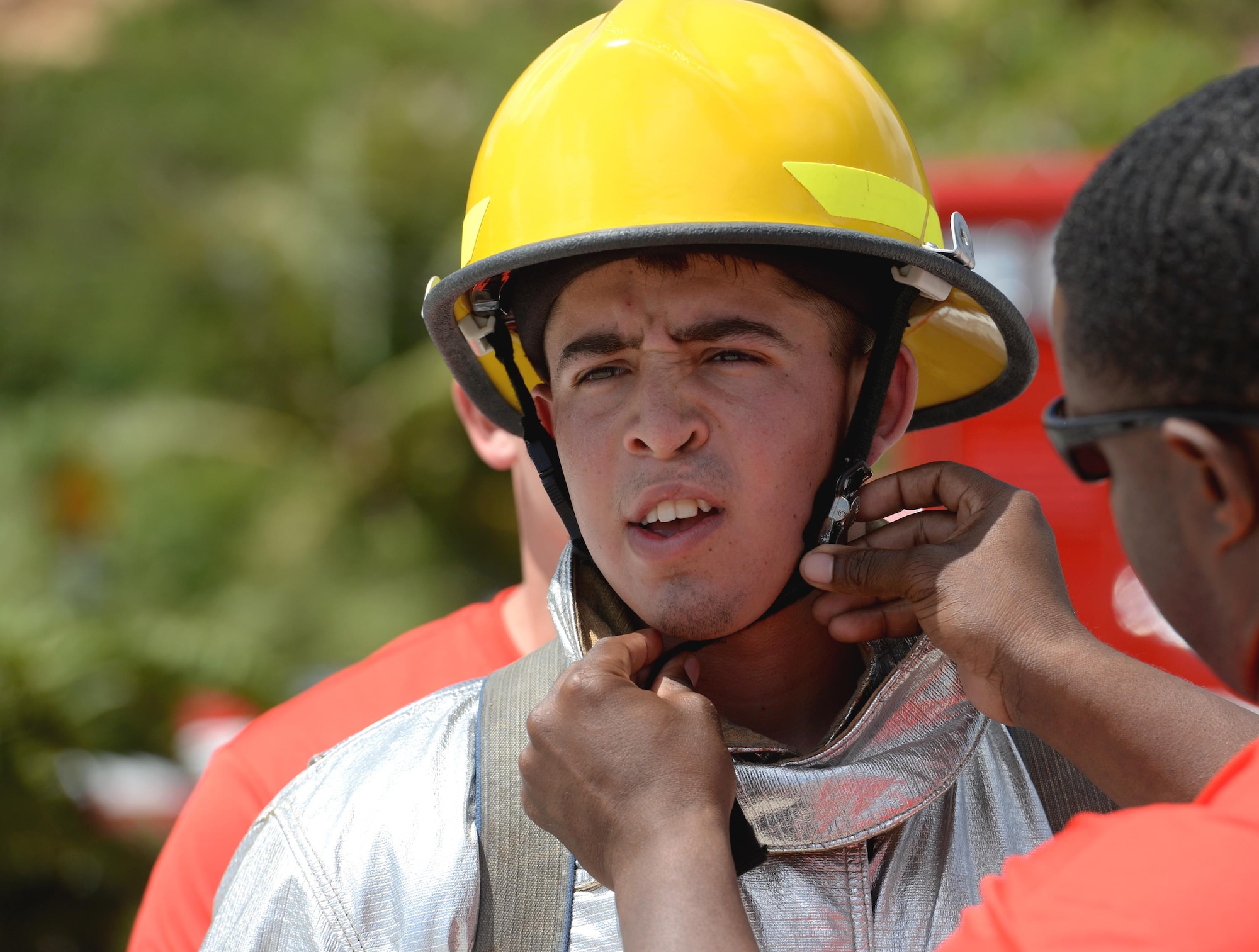 Airman 1st Class Jared May, 36th Civil Engineer Squadron fire protection crew chief, has his helmet fastened to his head during the annual Guam Fire Muster competition March 5, 2016, in Hagåtña, Guam. The fire muster tests a firefighter’s ability to perform basic firefighting techniques to include spraying a target with water, navigating through obstacles, carrying a casualty and using a sledgehammer. (U.S. Air Force photo/Staff Sgt. Benjamin Gonsier)