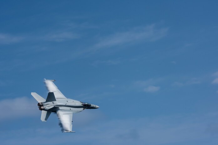 160307-N-GZ947-125 PHILIPPINE SEA (March 7, 2016) - Cmdr. Douglas Peterson flies an F/A-18E Super Hornet assigned to the Warhawks of Strike Fighter Squadron (VFA) 97 over USS John C. Stennis' (CVN 74) flight deck during an aerial change of command ceremony. Providing a ready force supporting security and stability in the Indo-Asia-Pacific, Stennis is operating as part of the Great Green Fleet on a regularly scheduled 7th Fleet deployment. (U.S. Navy photo by Mass Communication Specialist 3rd Class Kenneth Rodriguez Santiago / Released)