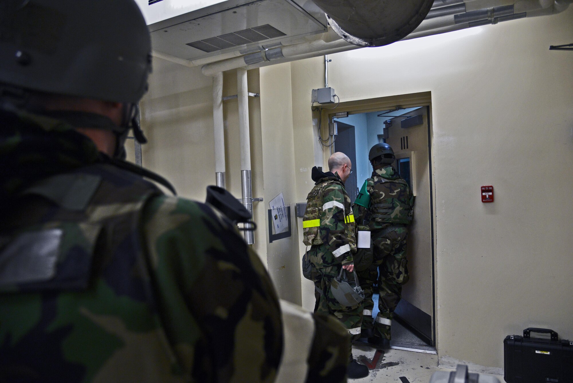 Staff Sgt. Derek Shull, 51st Fighter Wing Shelter Management Team member, stands watch as Senior Airman Lenard Rhett opens a secure door for an exiting Airman during exercise Beverly Midnight 16-01 at Osan Air Base, Republic of Korea, March 7, 2016. SMTs, through proper training, defend collective protection system buildings from contamination and unauthorized entry, keeping the building and its occupants safe. (U.S. Air Force photo by Tech. Sgt. Travis Edwards/Released)