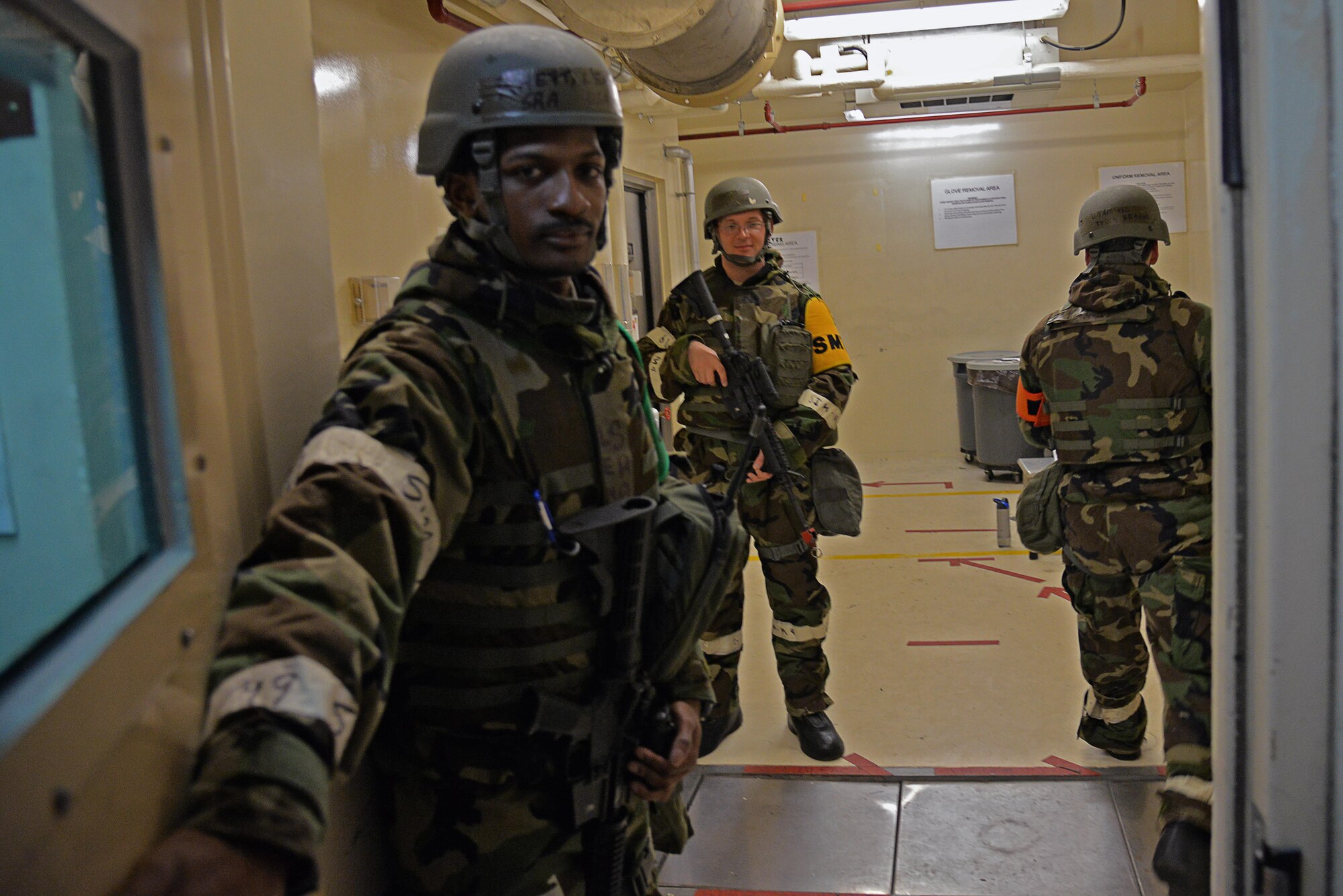 Senior Airman Lenard Rhett, 51st Fighter Wing Shelter Management Team member, opens a door to his building after verifying an Airman’s identity during exercise Beverly Midnight 16-01 at Osan Air Base, Republic of Korea, March 7, 2016. SMTs go through more than 12 hours of training to ensure they have the knowledge necessary to manage and defend collective protection system buildings from contamination and unauthorized entry, keeping the building and its occupants safe. (U.S. Air Force photo by Tech. Sgt. Travis Edwards/Released)