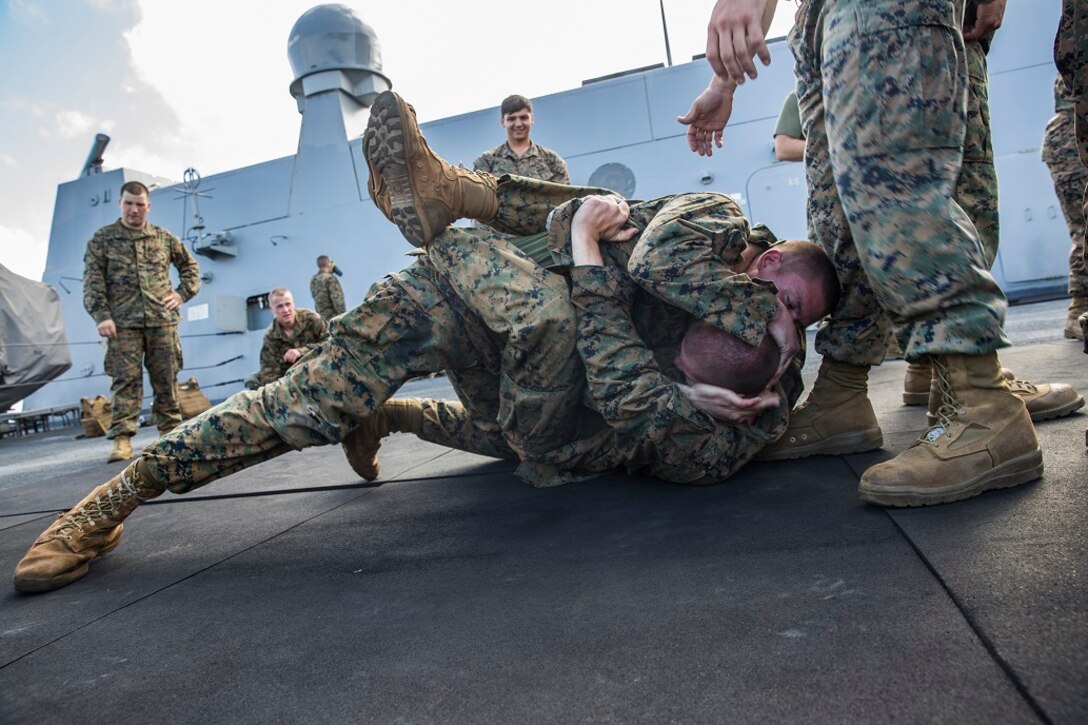 U.S. Marines with the 13th Marine Expeditionary Unit execute ground fighting techniques during a Marine Corps Martial Arts Program class aboard the USS New Orleans, at sea, Feb. 29, 2016. MCMAP builds the Marines' warrior ethos, while teaching combat techniques. More than 4,500 Sailors and Marines from the Boxer Amphibious Ready Group, 13th Marine Expeditionary Unit team are currently transiting the Pacific Ocean toward the U.S. 7th Fleet area of operations during a scheduled deployment. (U.S. Marine Corps photo by Lance Cpl. Alvin Pujols/RELEASED)