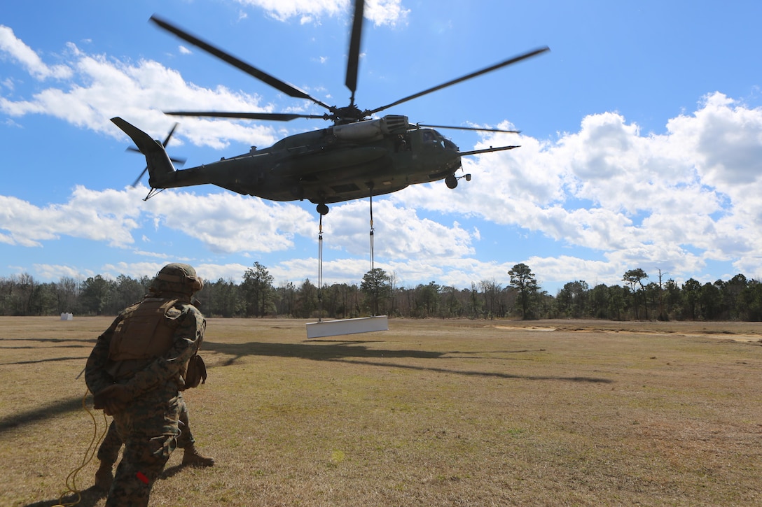 A CH-53E Super Stallion lifts cargo during a helicopter support training exercise, aided by Marines with Landing Support Platoon, Combat Logistics Battalion 2 at Marine Corps Base Camp Lejeune, N.C., March 2, 2016.  Helicopter support team missions are critical to mission accomplishment because they provide the ability to quickly and efficiently provide support to other Marines on the ground, and they assist with the loading and unloading of important equipment such as small vehicles, supplies, and food rations in a moment’s notice.