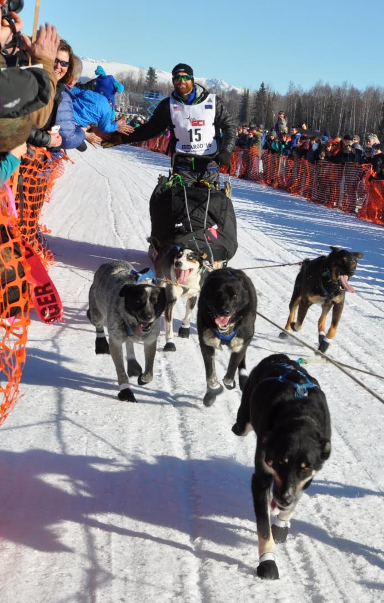 James Volek high-fives fans as he sets out on the race trail at the Iditarod restart in Willow Alaska, March 6, 2016. The Iditarod is a 1,000-mile sled dog race across the rugged terrain of Alaska. This is the second year Air Force Reserve Recruiting has sponsored the Iditarod, known as “The Last Great Race on Earth.”(U.S. Air Force/Tech. Sgt. Kimberly Rae Moore)