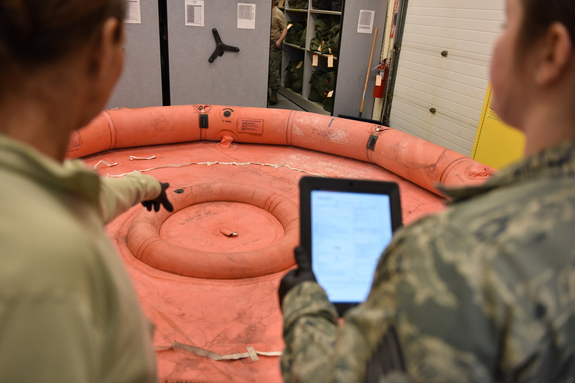 Staff Sgt. Brenda Murray and Tech. Sgt. Kayla Hutton, aircrew flight equipment technicians with the 911th Airlift Wing aircrew flight equipment shop, check the stenciling on a 20 person life raft for a C-130 Hercules at the Pittsburgh International Airport Air Reserve Station, March 5, 2016. The lettered stenciling on the raft indicates where equipment is stored or can be safely tied down. (U.S. Air Force photo by Senior Airman Marjorie A. Bowlden)