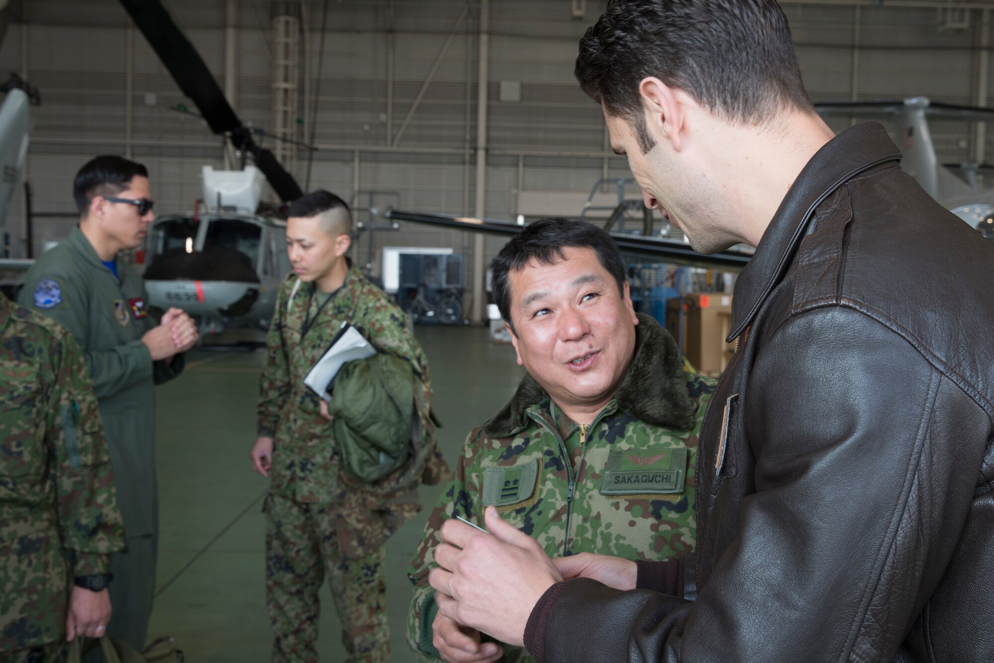 (Right to left) U.S. Air Force Lt. Col. William Martin, 459th Airlift Squadron commander, and Japan Ground Self-Defense Force Lt. Col. Tatsuro Sakaguchi, Eastern Army Helicopter, 1st Aviation executive officer, talks after a hoist demonstration by JGSDF members at Yokota Air Base, Japan, March 4, 2016.  JGSDF 1st Aviation and USAF 459th AS crewmembers exchanged search and rescue knowledge through hoist demonstrations. (U.S. Air Force photo by Osakabe Yasuo/Released) 