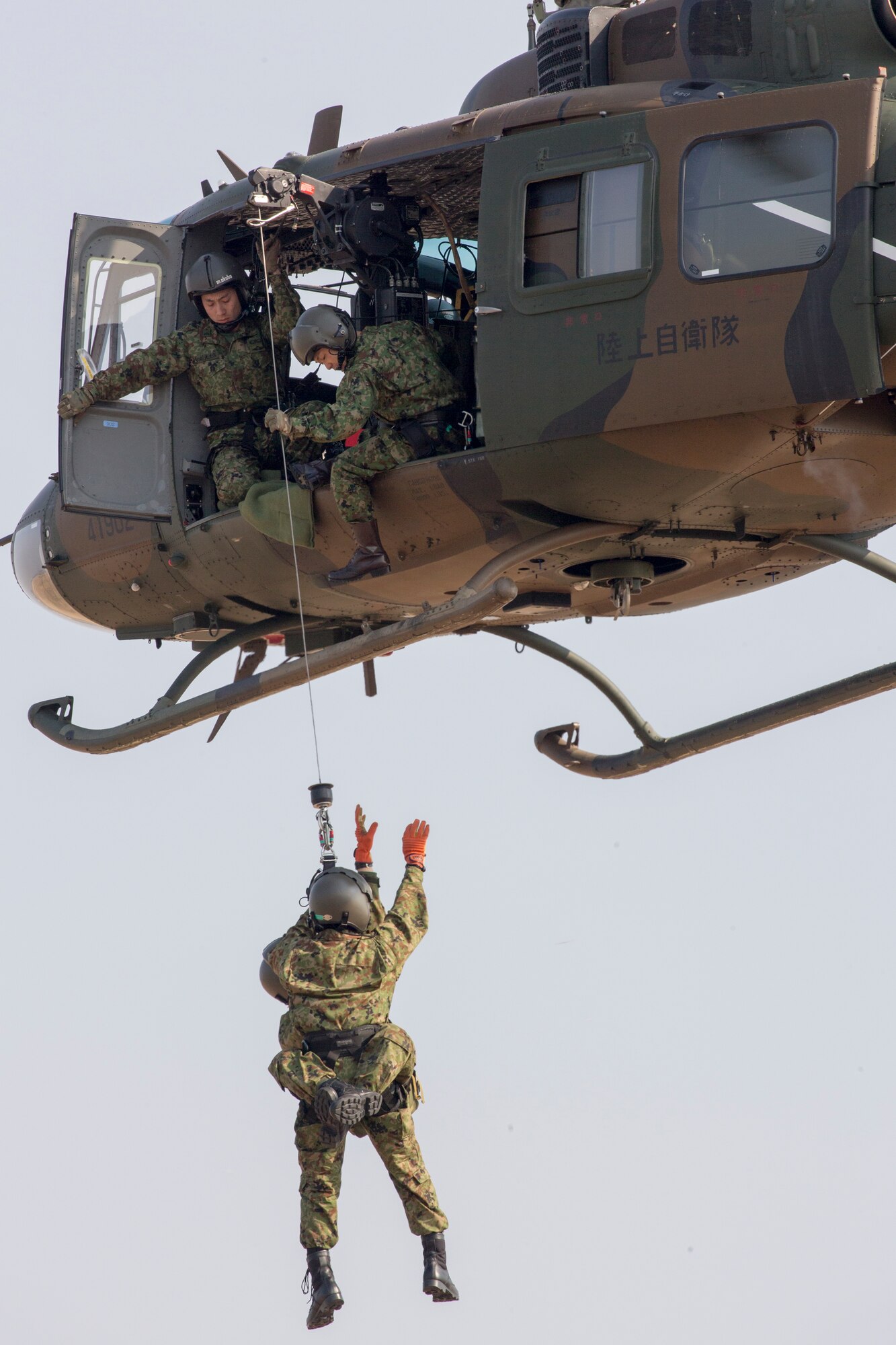 Japan Ground Self-Defense Force members with the Eastern Army Helicopter, 1st Aviation perform a hoist demonstration at Yokota Air Force, Japan, March 4, 2016.  JGSDF members with the 1st Aviation supported the Kinugawa flood last year and rescued 104 people and 4 dogs in one hour. (U.S. Air Force photo by Osakabe Yasuo/Released)