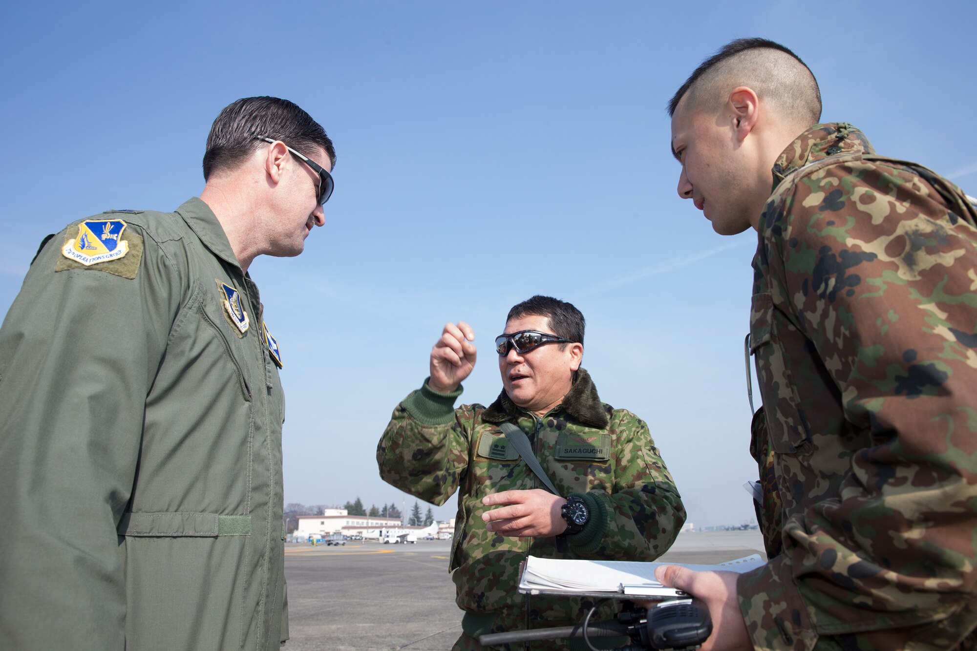 (Center and left) Japan Ground Self-Defense Force Lt. Col. Tatsuro Sakaguchi, Eastern Army Helicopter, 1st Aviation Unit executive officer, talks to U.S. Air Force Col. Robert Dotson, 374th Operations Group commander, during search and rescue familiarization at Yokota Air Base, Japan, March 4, 2016. JGSDF members demonstrated their hoist capabilities to 459th Airlift Squadron members. (U.S. Air Force photo by Osakabe Yasuo/Released)