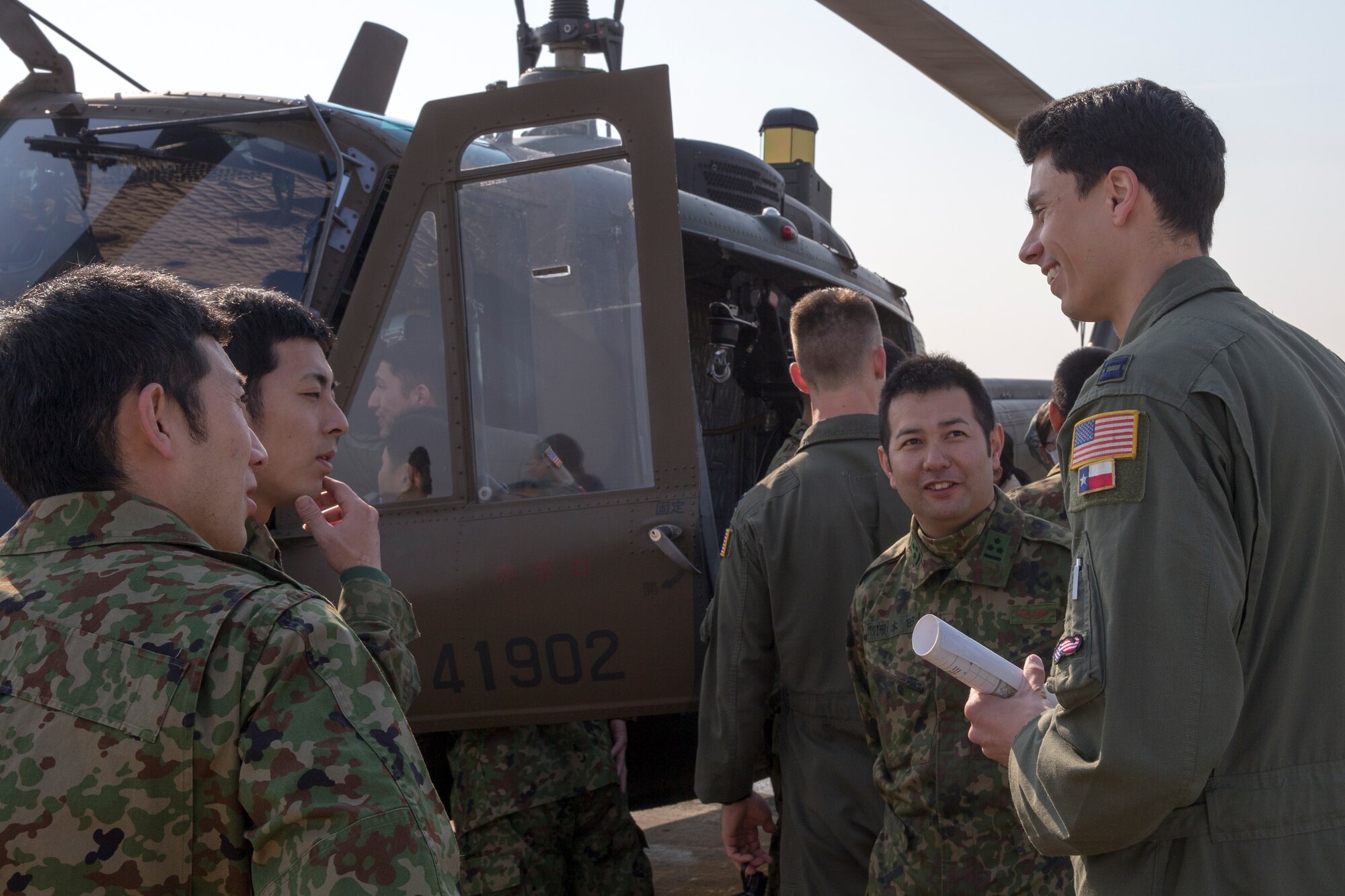 U.S. Air Force Capt. Caniel Trapani, 459th Airlift Squadron UH-1 pilot, talks to Japan Ground Self-Defense Force members from the Eastern Army Helicopter, 1st Aviation Unit at Yokota Air Base, Japan, March 4, 2016. JGSDF members demonstrated their hoist capabilities to 459th AS members for search and rescue familiarization between U.S. and Japan. (U.S. Air Force photo by Osakabe Yasuo/Released) 