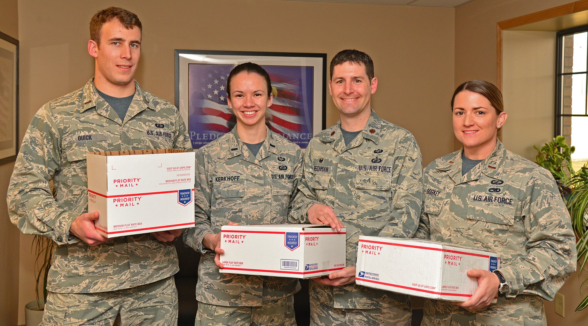 From left, 2nd Lt. Aaron Quick, 1st Lt. Deanna Kerkhoff, Maj. Jeremiah Kirschman and 2nd Lt. Teresa Doskey, all members of the 341st Contracting Squadron, pose with care packages March 4, 2016, at Malmstrom Air Force Base, Mont. The 341st CONS created a deployment plan that includes sending their deployed Airmen care packages and allowing open communication between units. (U.S. Air Force photo/Airman Daniel Brosam)
