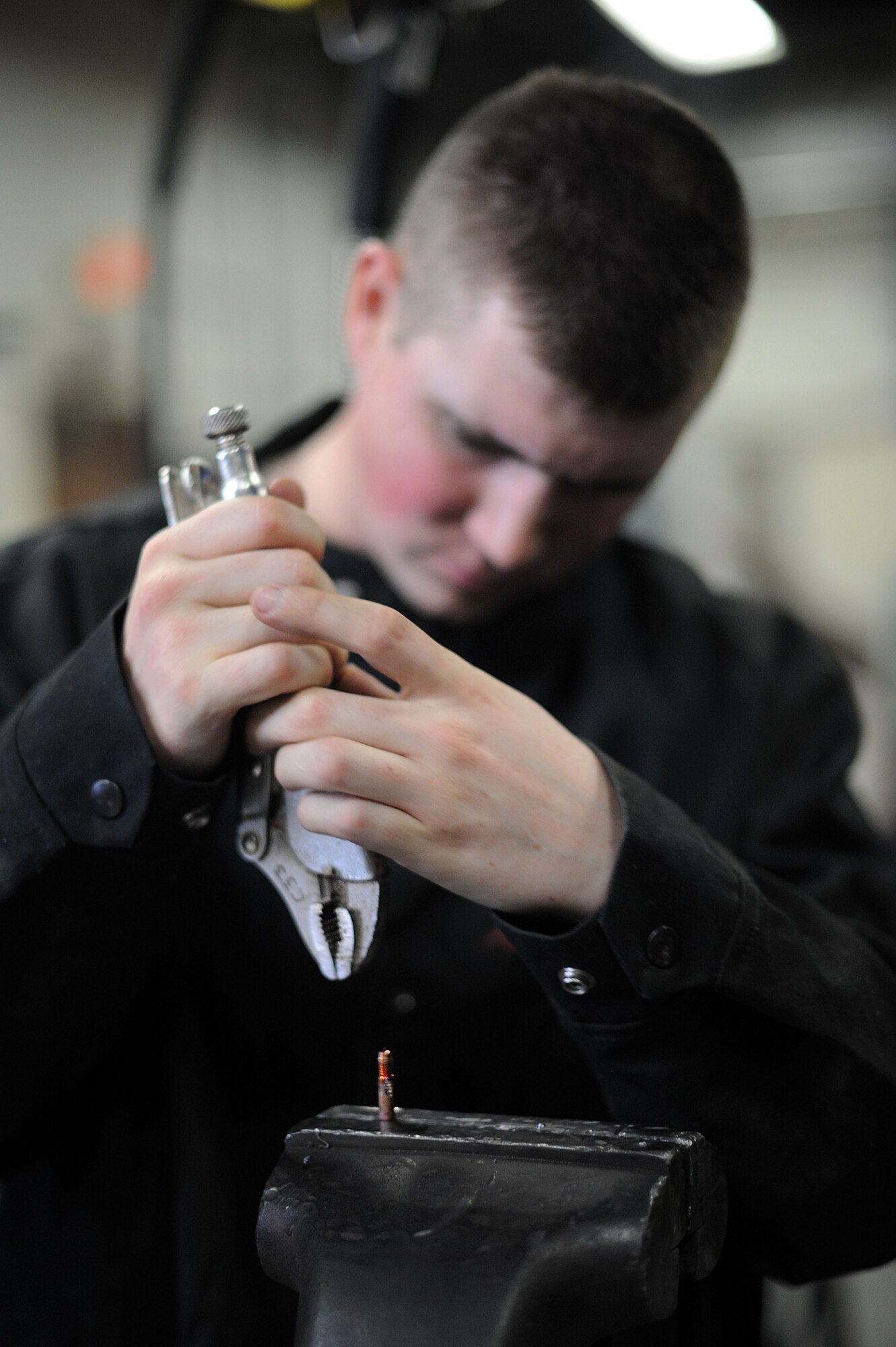 Senior Airman Garrett Bowen, 22nd Civil Engineer Squadron structural apprentice, fixes the copper tip of a welding torch, March 3, 2016, at McConnell Air Force Base, Kan. The copper tip must be in proper working condition because it protects the wire and helps maintain electrical contact during welding.  (U.S. Air Force photo/Airman Jenna K. Caldwell)  