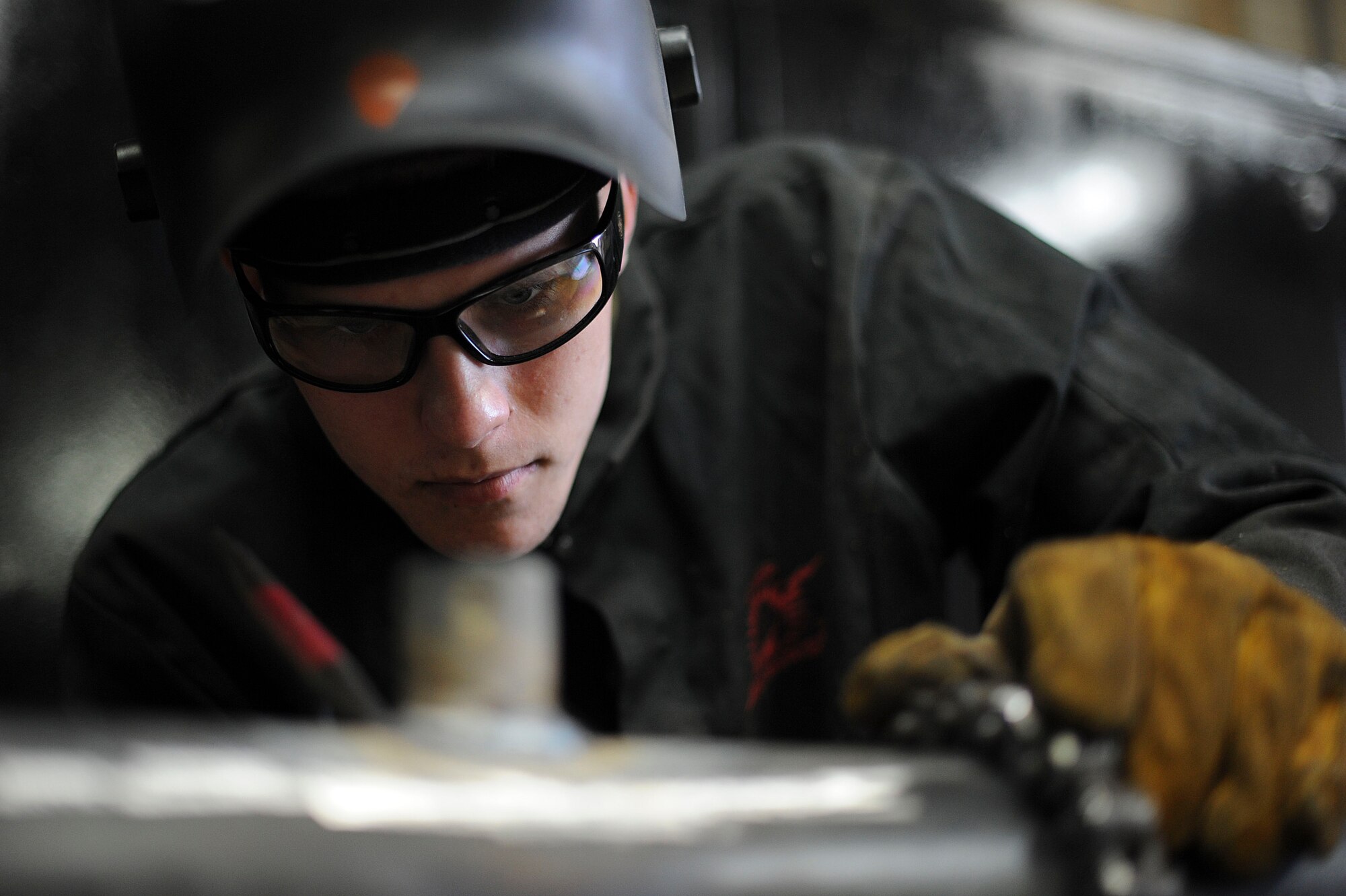 Airman 1st Class James Ori, 22nd Civil Engineer Squadron structural journeyman, inspects his welding work for gaps or air bubbles, March 3, 2016, at McConnell Air Force Base, Kan. The Airmen wear leather gloves, safety glasses and self-darkening welding helmets to protect against burns and ensure safety in the workplace. (U.S. Air Force photo/Airman Jenna K. Caldwell)  