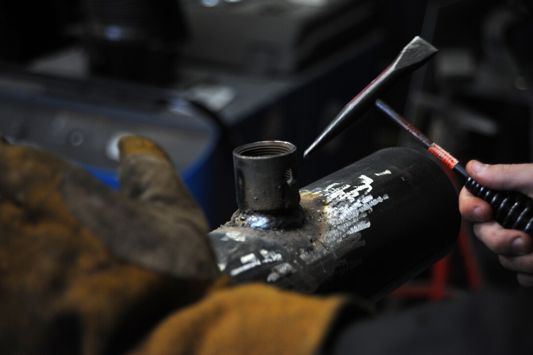Airman 1st Class James Ori, 22nd Civil Engineer Squadron structural journeyman, removes metal spatter on a weld, March 3, 2016, at McConnell Air Force Base, Kan. The Airmen maintain and repair any metal, wood or masonry facility issues on base. (U.S. Air Force photo/Airman Jenna K. Caldwell)  