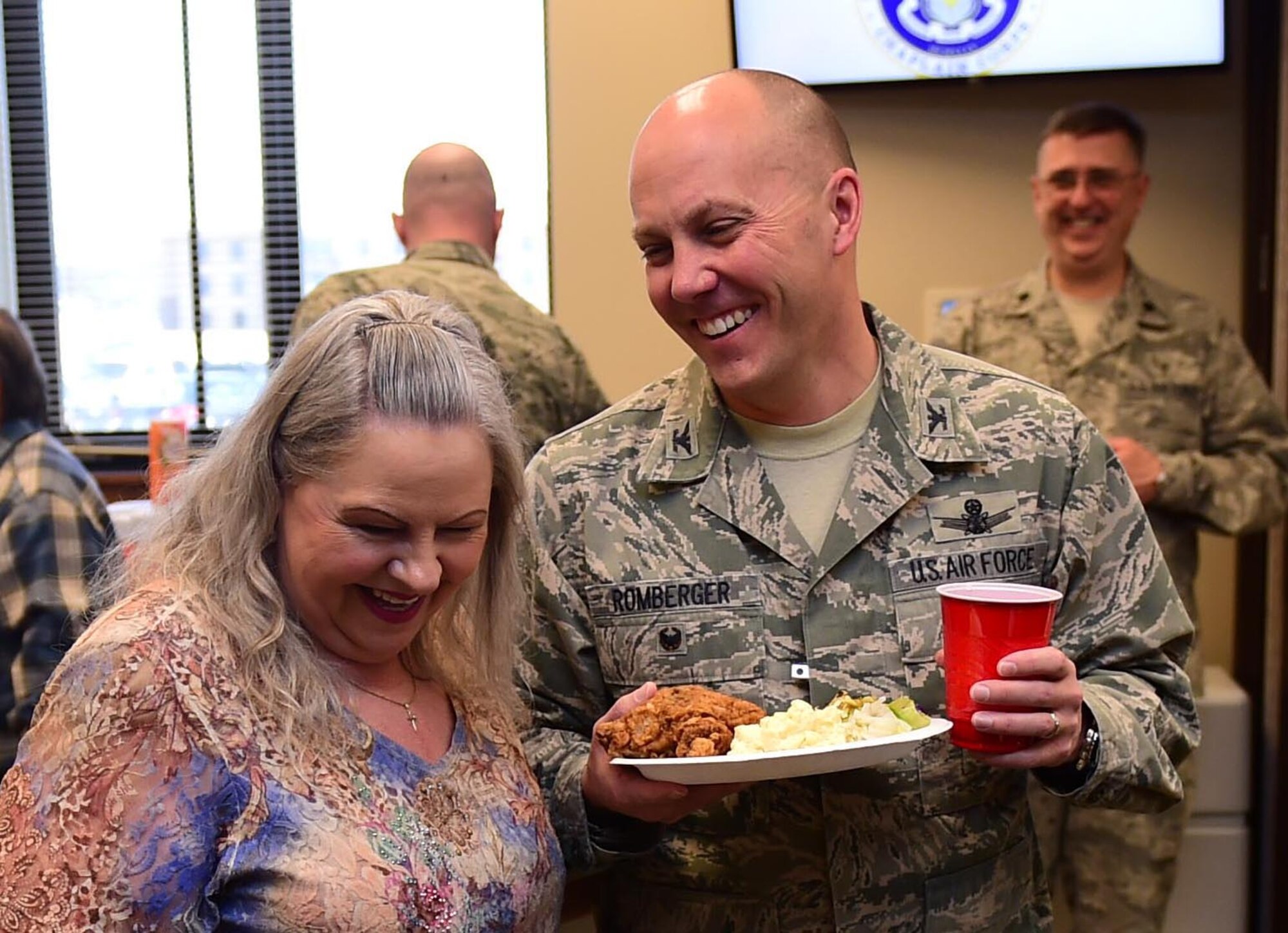 Debbie Cruz, 460th Space Wing chapel secretary, and Col. Scott Romberger, 460th Space Wing vice commander, talk and laugh during th monthly fellowship luncheon Mar. 2, 2016, at the Buckley Chapel fellowship hall on Buckley Air Force Base, Colo. The monthly luncheon brings members of Team Buckley from every rank, branch and even civilians together for fellowship and food the first Wednesday of every month. (U.S. Air Force photo by Airman 1st Class Gabrielle Spradling/Released)