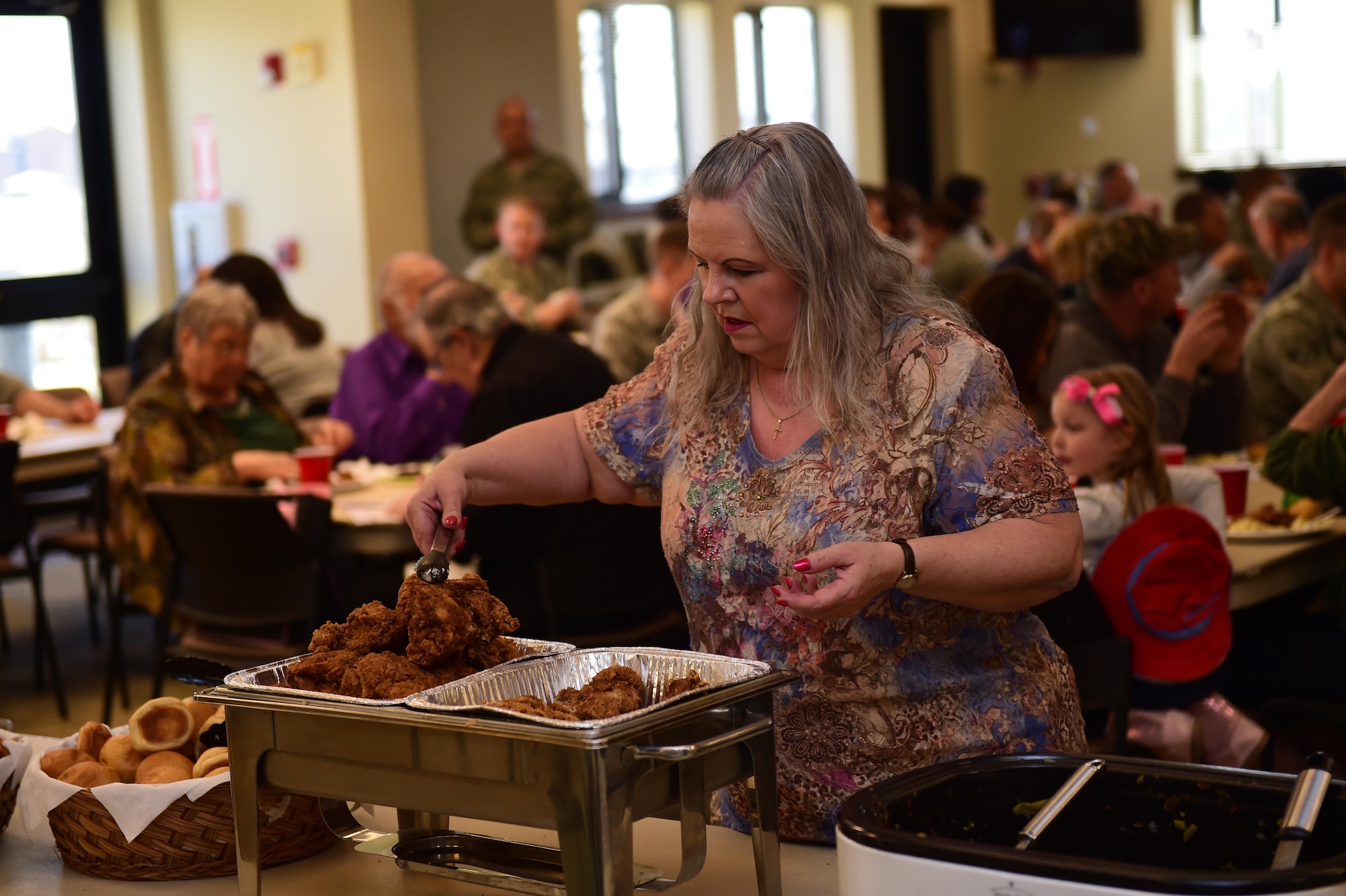 Debbie Cruz, 460th Space Wing chapel secretary, replenishes the fried chicken for the fellowship luncheon Mar. 2, 2016, at the Buckley Chapel Fellowship Hall on Buckley Air Force Base, Colo. Cruz is responsible for all of the preparations of the lunch and works while everyone else enjoyed the meal she organized. (U.S. Air Force photo by Airman 1st Class Gabrielle Spradling/Released)