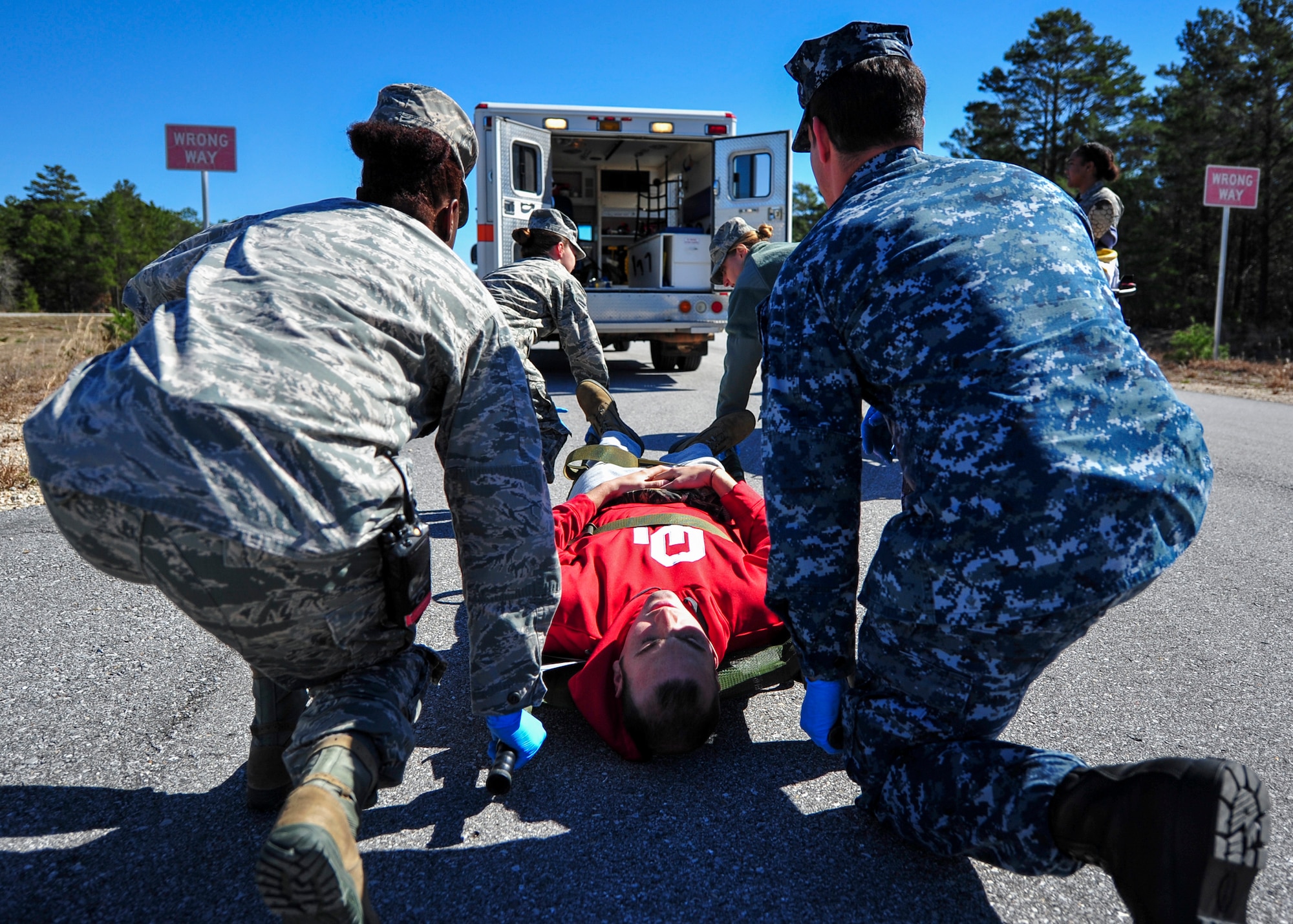 Airmen and a Sailor, carry one of the injured on a stretcher board during a mass casualty exercise Feb. 25 at Eglin Air Force Base, Fla. Base medical emergency personnel, firefighters and defenders practiced rescue and safety skills during the simulated two-vehicle accident that caused 19 injuries and one death. (U.S. Air Force photo/Ilka Cole)
