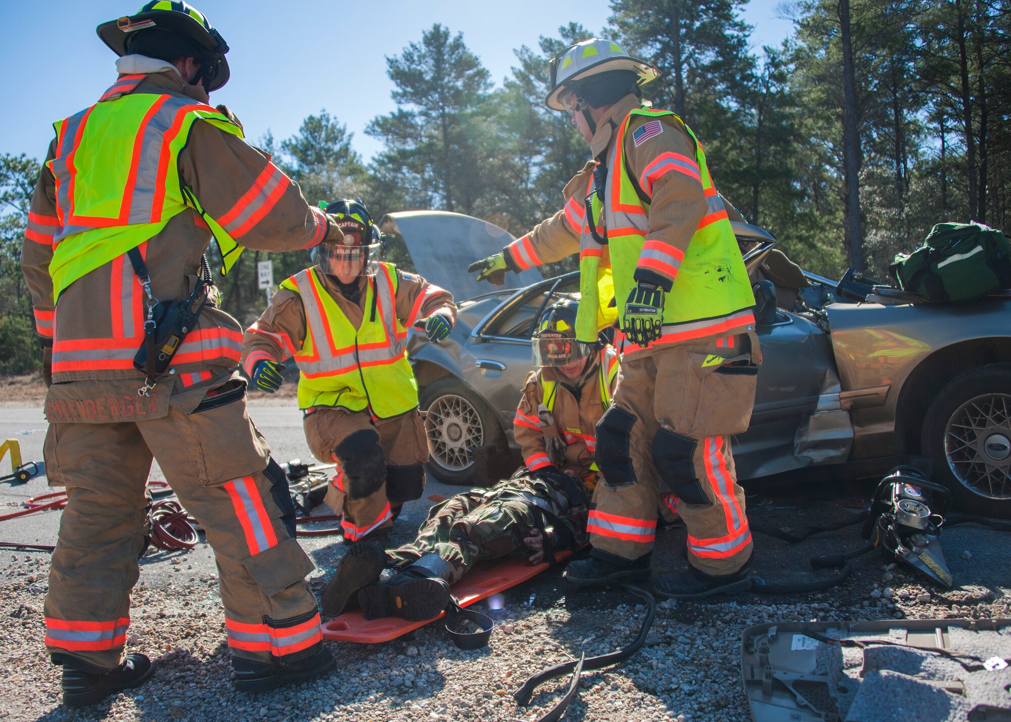 96th Civil Engineer Group firefighters secure a crash dummy to an emergency stretcher board during a mass casualty exercise Feb. 25 at Eglin Air Force Base, Fla. Base medical emergency personnel, firefighters and defenders practiced rescue and safety skills during the simulated two-vehicle accident that caused 19 injuries and one death. (U.S. Air Force photo/Ilka Cole)