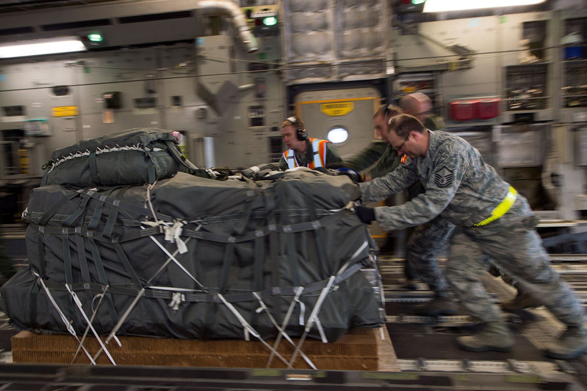 Airmen from Joint Base Elmendorf-Richardson push more than 12,000 pounds of cargo into the back of a C-17 Globemaster III at JBER, Alaska, March 2, 2016.  (U.S. Air Force photo by Staff Sgt. Sheila deVera)

