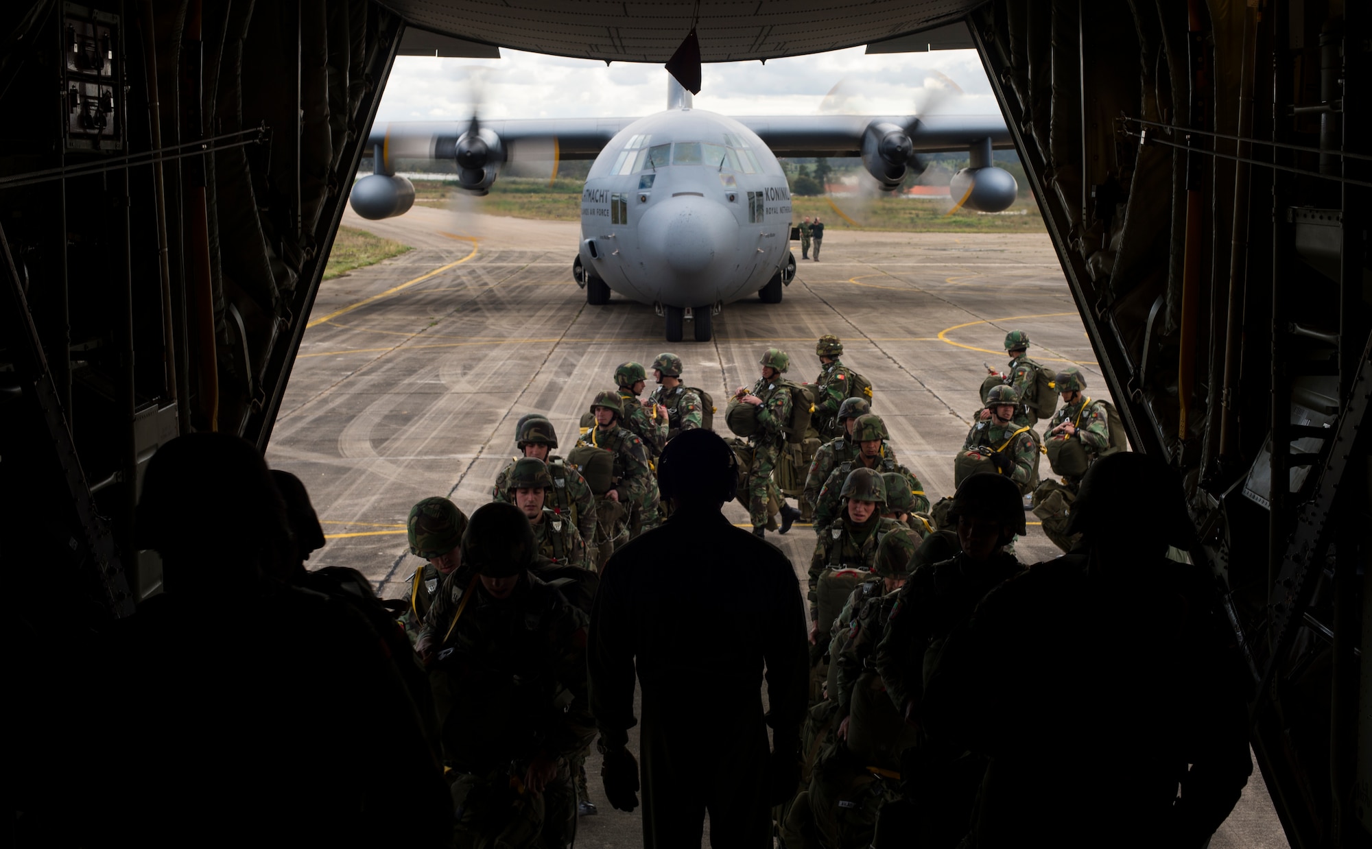 Portuguese paratroopers load onto a C-130J Super Hercules assigned to the 37th Airlift Squadron anda C-130H Hercules assigned to the Netherland air force during exercise Real Thaw 16 in Beja, Portugal, Feb. 25, 2016. The U.S. worked alongside the Royal Netherlands air force to airdrop more than 100 paratroopers. (U.S. Air Force photo/Senior Airman Jonathan Stefanko)