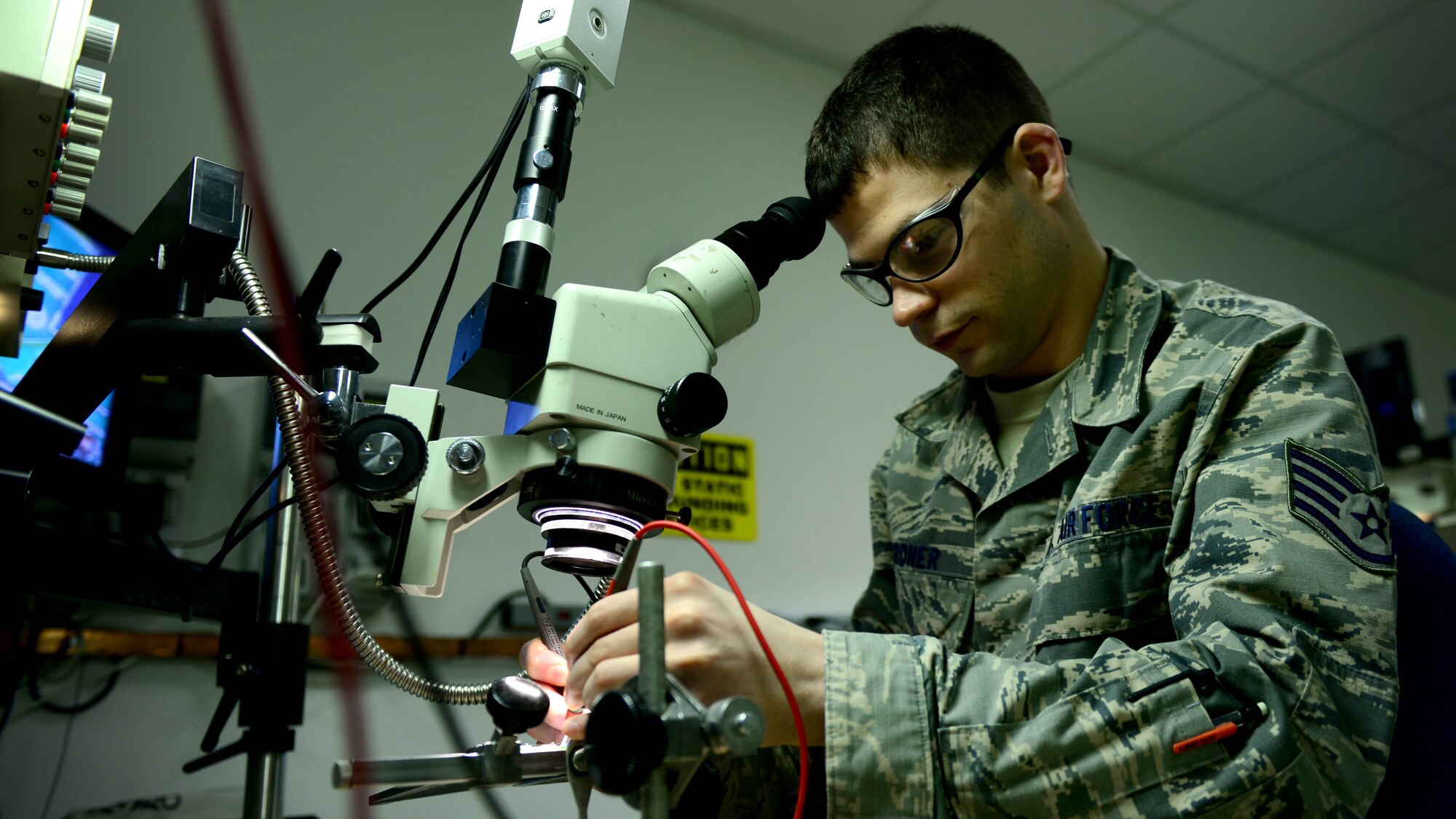 Staff Sgt. Phillip Gardner, 31st Maintenance Group Air Force Repair Enhancement Program technician, uses a microscope to perform precise soldering repairs on circuit card components, Feb. 25, 2016, at Aviano Air Base, Italy. AFREP fixes items ranging from aircraft parts to televisons to help save taxpayer dollars. (U.S. Air Force photo by Senior Airman Areca T. Bell/Released)