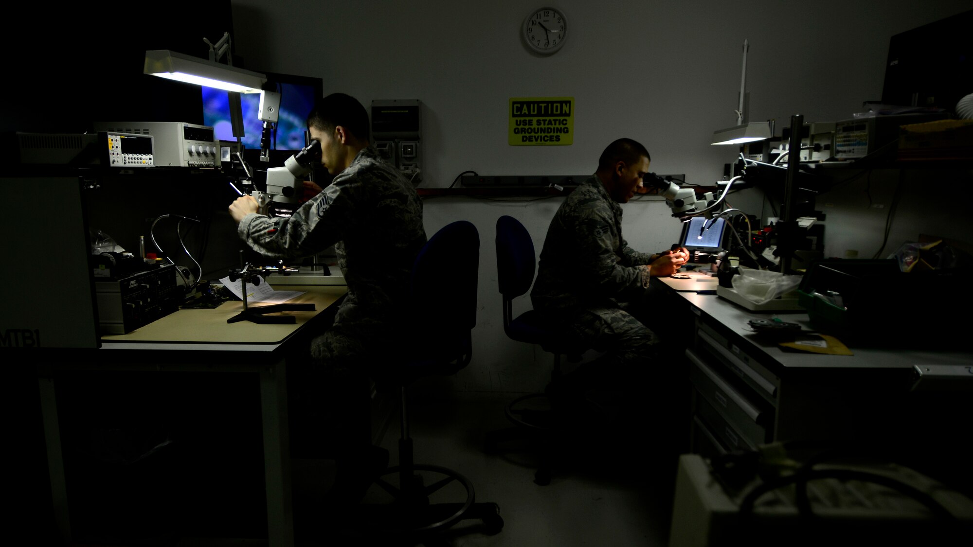(From left) Staff Sgt. Phillip Gardner and Senior Airman Edgar Diaz, 31st Maintenance Group Air Force Repair Enhancement Program technicians, use microscopes to perform precise soldering repairs on circuit card components, Feb. 25, 2016, at Aviano Air Base, Italy. During fiscal year 2015, AFREP fixed an average of 12 items per month, subsequently saving Aviano Air Base more than $1.2 million and earning $539,000. (U.S. Air Force photo by Senior Airman Areca T. Bell/Released)