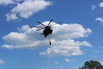 A CH-53E Super Stallion lifts cargo during a helicopter support training exercise aided by Marines with Landing Support platoon, Combat Logistics Battalion 2 aboard Camp Lejeune, N.C., March 2, 2016. The Marines underneath the Super Stallion all have critical roles in ensuring mission accomplishment, working together to attach the equipment on the ground  to the helicopter while it hovers in the air about 10 feet above them.  In real world events, helicopter support team missions are critical to mission accomplishment because they provide the ability to quickly and efficiently provide support to Marines on the ground, loading and unloading important equipment such as small vehicles, supplies, and food rations in a moment’s notice. (Marine Corps photo by Cpl. Shannon Kroening)