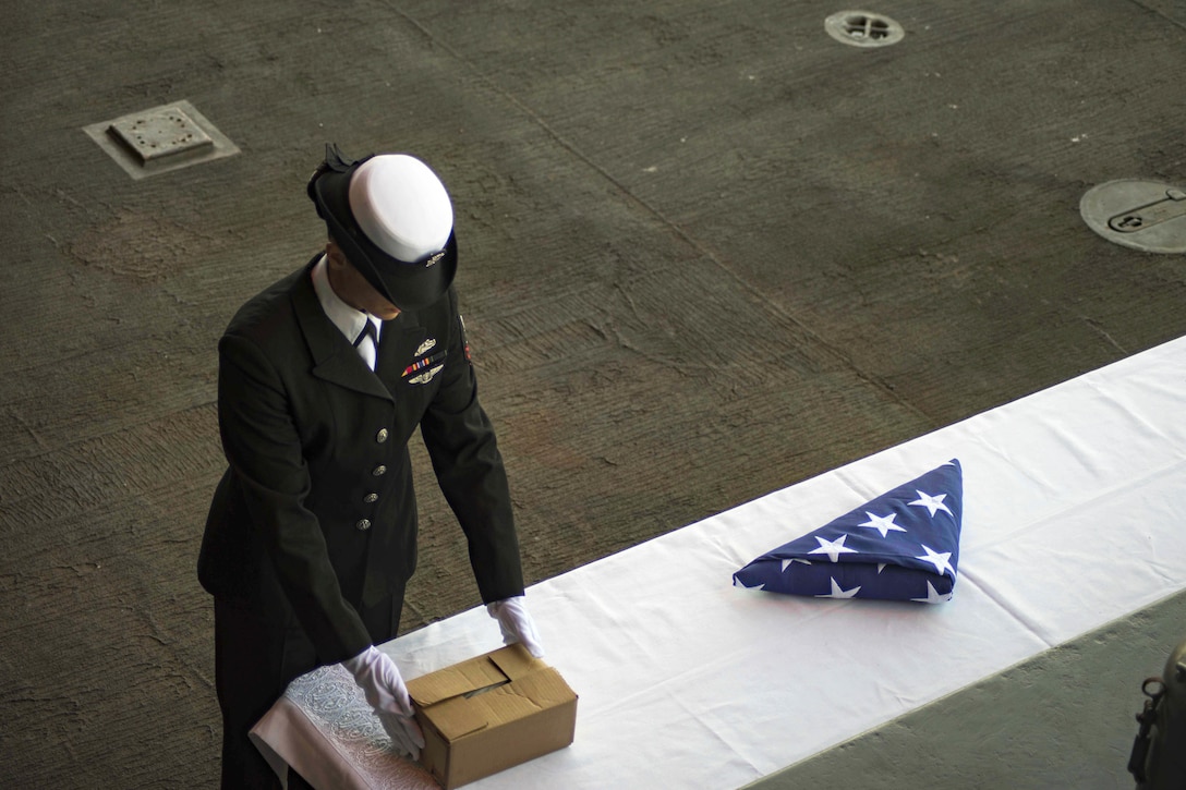 Navy Petty Officer 2nd Class Blanca Arredondo gathers the remains of a deceased sailor during a burial at sea on the fantail of the aircraft carrier USS Dwight D. Eisenhower in the Atlantic Ocean, March 1, 2016. Arredondo is a boatswain’s mate. Navy photo by Seaman Nathan Beard