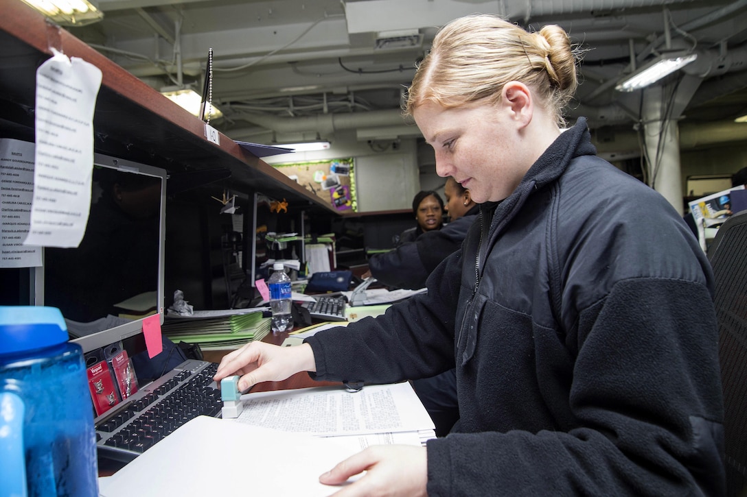 Navy Seaman Christina Burgess reviews paperwork in the personnel office of the aircraft carrier USS Dwight D. Eisenhower in the Atlantic Ocean, March 2, 2016. Burgess is a personnel specialist. Navy photo by Petty Officer 3rd Class Anderson W. Branch