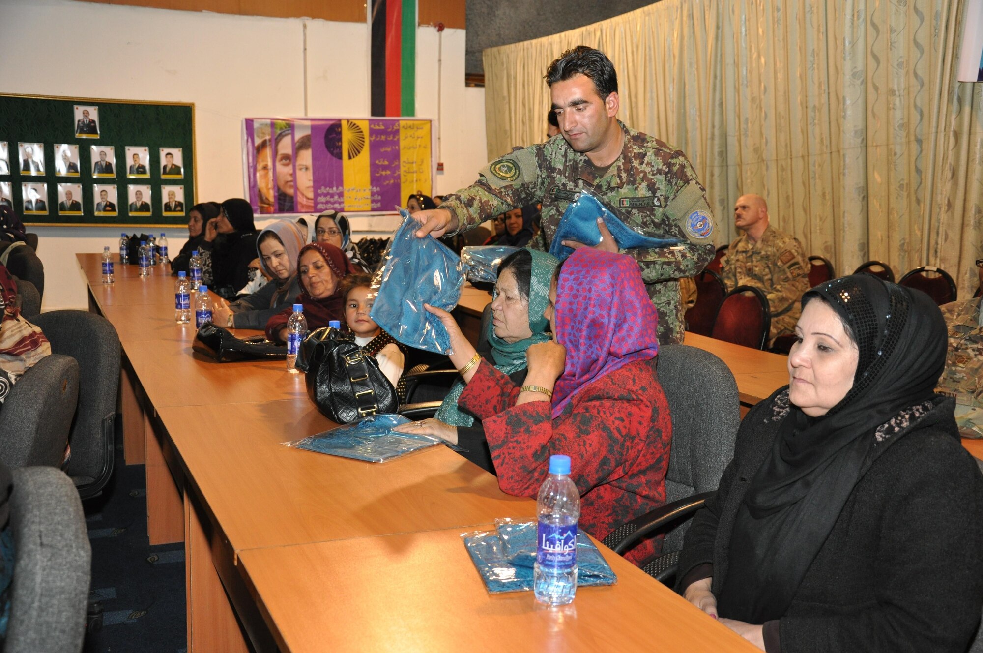 An Afghan air force soldier passes out scarves to the attendees of the AAF’s International Women’s Day conference March 6, 2016, at Kabul Air Wing, Kabul, Afghanistan. Approximately 200 AAF and Train, Advise, Assist Command-Air (TAAC-Air) military men and women attended the event to include guest speakers from the AAF commander to women educators and officers. (U.S. Air Force photo by Capt. Eydie Sakura/released)