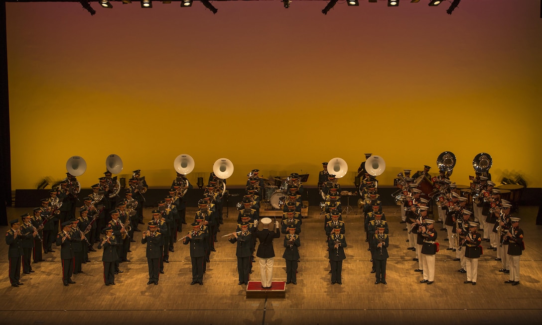 Marines with the III Marine Expeditionary Force band alongside the Western Army band participate in a joint performance Mar. 5 in Sojo Daigaku Hall in Kumamoto, Japan. They are performing Hands Across the Sea, a marching song composed by John Philip Sousa. The music festival marks the 60th anniversary of the Western Army Band. (U.S. Marine Corps photo by Cpl. Tyler Ngiraswei/ Released)