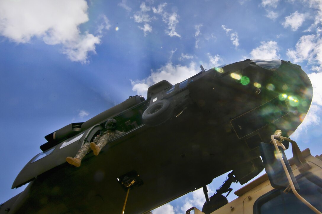 An Army crew chief looks down on cargo during slingload training at Coyle drop zone on Joint Base McGuire-Dix-Lakehurst, N.J., Feb. 29, 2016. The crew chief is assigned to the New Jersey National Guard's 1st Battalion, 150th Assault Helicopter Battalion. New Jersey Air National Guard photo by Tech. Sgt. Matt Hecht