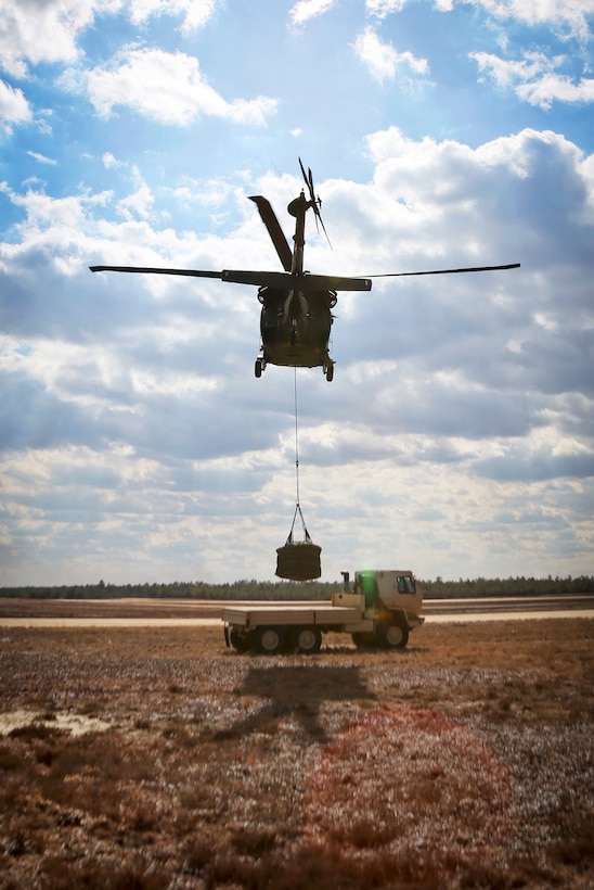 A UH-60 Black Hawk helicopter lifts off with cargo during slingload training at Coyle drop zone on Joint Base McGuire-Dix-Lakehurst, N.J., Feb. 29, 2016. New Jersey Air National Guard photo by Tech. Sgt. Matt Hecht
