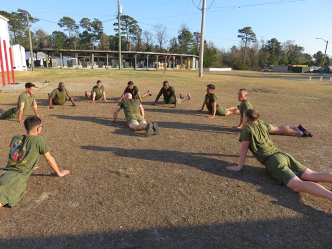 Marines attending Advanced Water Support Technician course 2-16 (AWST 2-16) participate in stretching exercises before physical training at Camp Sweat training area on Courthouse Bay, Camp Lejeune, North Carolina.  
