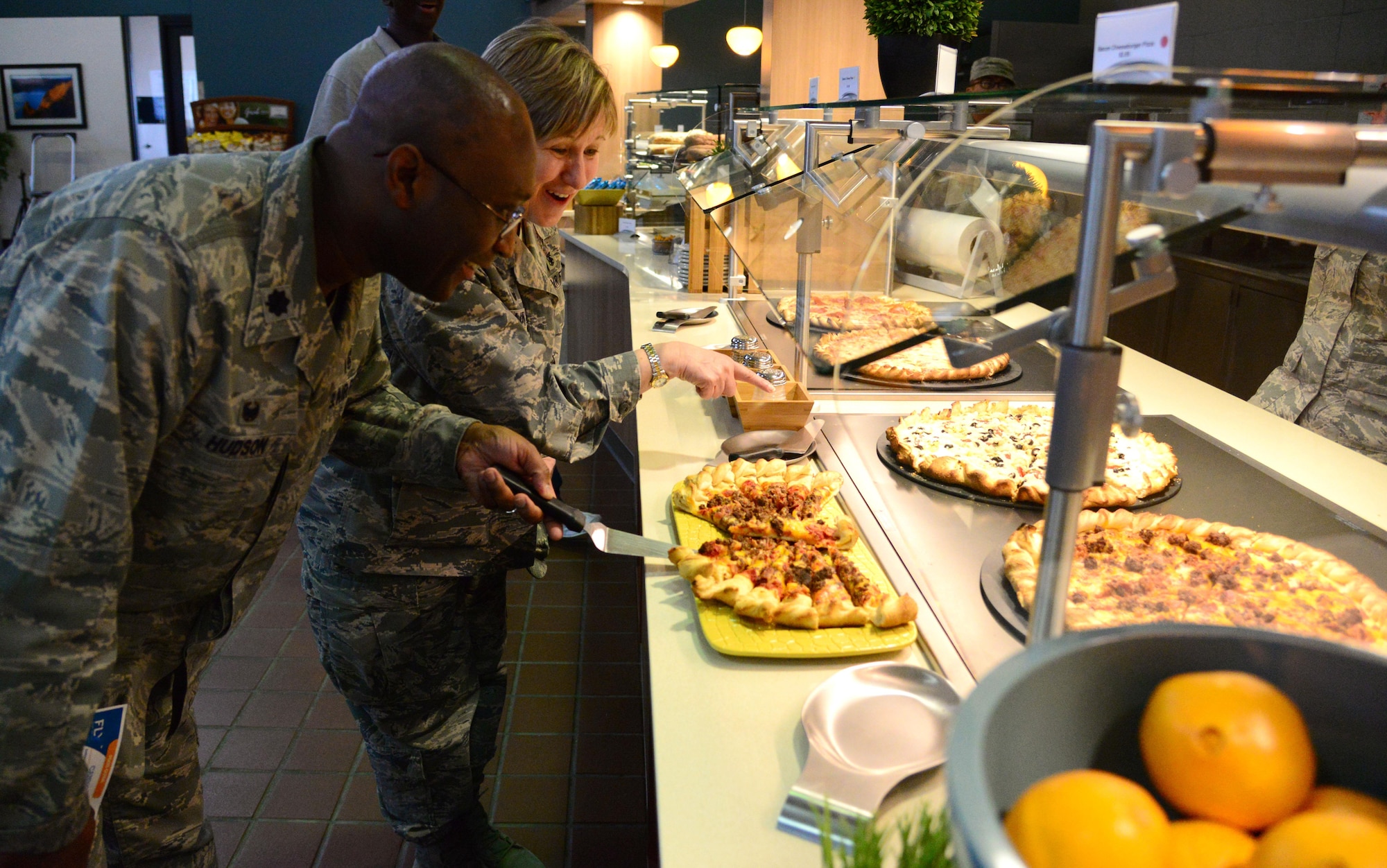 Lt. Col. Curtis Hudson, 27th Special Operations Medical Support Squadron commander, and Lt. Col. Barbara Cain, 27th Special Operations Medical Operations Squadron commander, enjoy free samplings of food during the grand opening of the Pecos Trail Dining Facility March 3, 2016, at Cannon Air Force Base, N.M. Leaders noted that they are diligently working toward creating an environment for Airmen and families to thrive, and this is simply another milestone in that journey. (U.S. Air Force photo/Staff Sgt. Alexx Pons) 