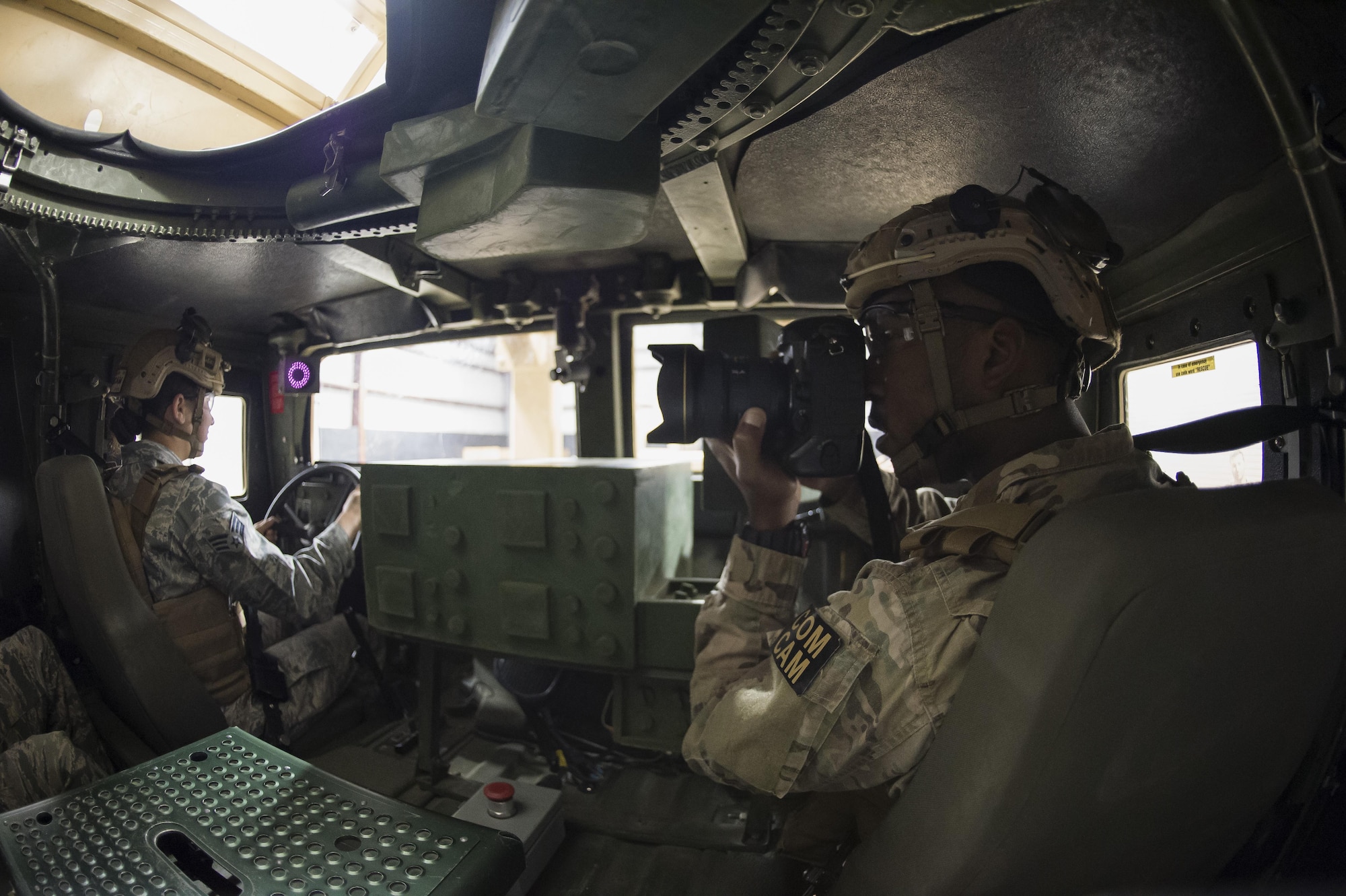 Staff Sgt. Paul Labbe, a 1st Combat Camera Squadron combat photojournalist, takes a photo inside a Humvee egress simulator March 3, 2016, during exercise Scorpion Lens 2016, at McCrady Training Center on Fort Jackson, S.C. The exercise is an annual training requirement incorporating combat camera job qualification standards and advanced weapons and tactical training with Army instructors. (U.S. Air Force photo/Staff Sgt. Jared Trimarchi)