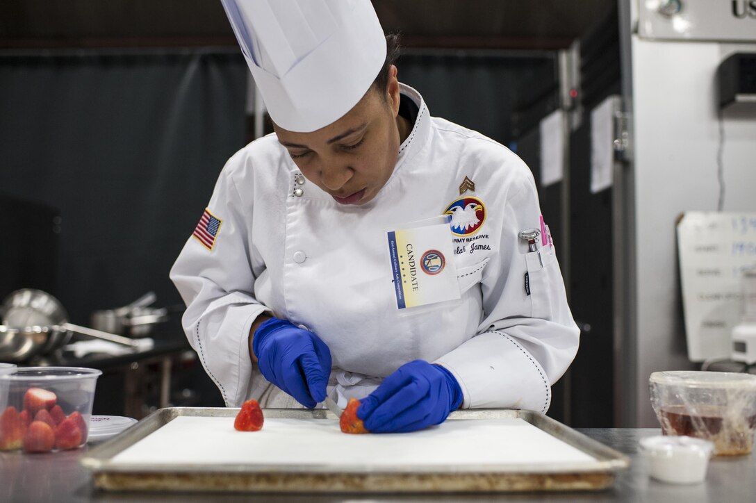 Staff Sgt. Aqueelah James, a U.S. Army Reserve Culinary Team member with the 3rd Medical Command (Deployment Support), Fort Gillem, Ga., slices strawberries for her Island Dream Dessert during the Practical and Contemporary Hot Food Cooking/Patisserie category at the 41st Annual Military Culinary Arts Competitive Training Event, March 7, 2016, at Fort Lee, Va. James, who earned a silver medal in the category, used the influences of her family heritage from the islands of Saint Kitts and Nevis and the Dominican Republic as inspiration for the dessert. (U.S. Army photo by Timothy L. Hale/Released)