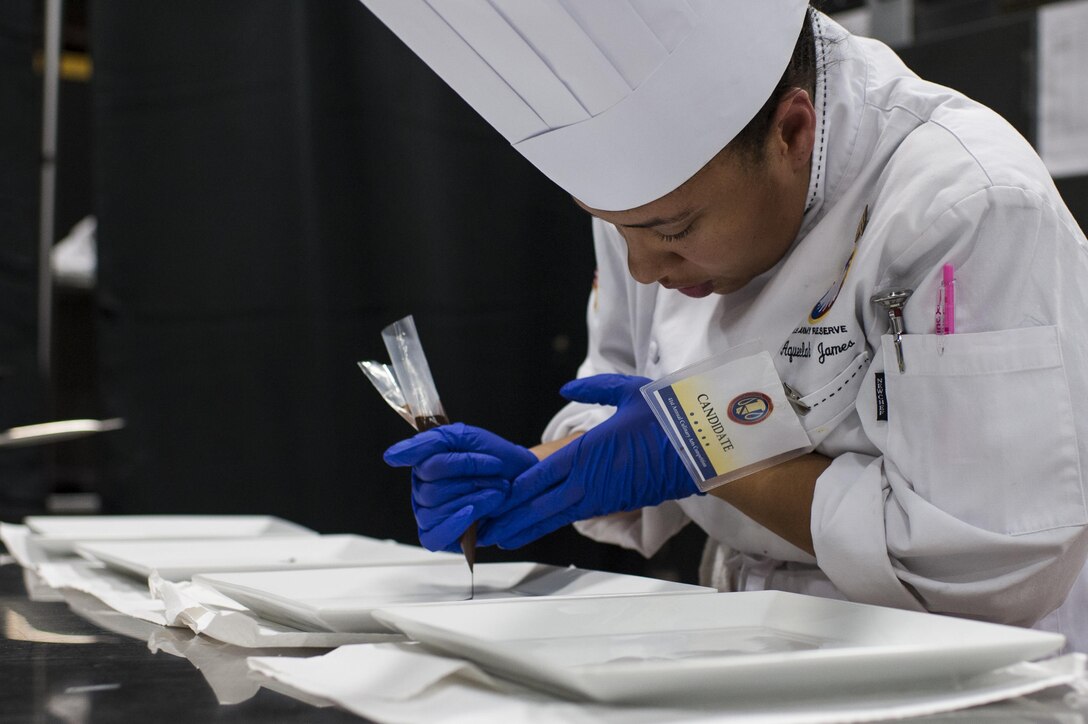 Staff Sgt. Aqueelah James, a U.S. Army Reserve Culinary Team member with the 3rd Medical Command (Deployment Support), Fort Gillem, Ga., pipes chocolate onto a plate for her Island Dream Dessert during the Practical and Contemporary Hot Food Cooking/Patisserie category at the 41st Annual Military Culinary Arts Competitive Training Event, March 7, 2016, at Fort Lee, Va. James, who earned a silver medal in the category, used the influences of her family heritage from the islands of Saint Kitts and Nevis and the Dominican Republic as inspiration for the dessert. (U.S. Army photo by Timothy L. Hale/Released)